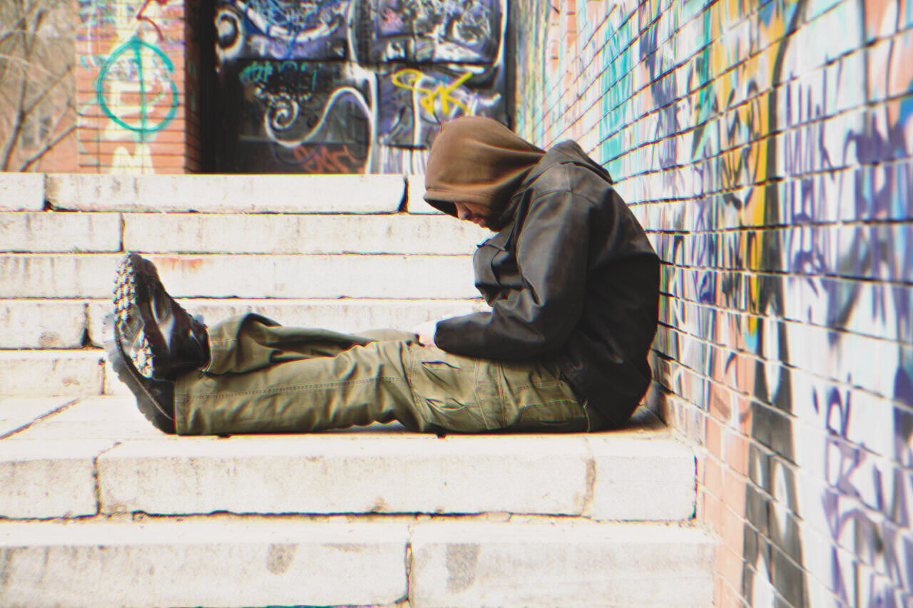 Hombre sin hogar sentado en la calle | Foto: Shutterstock