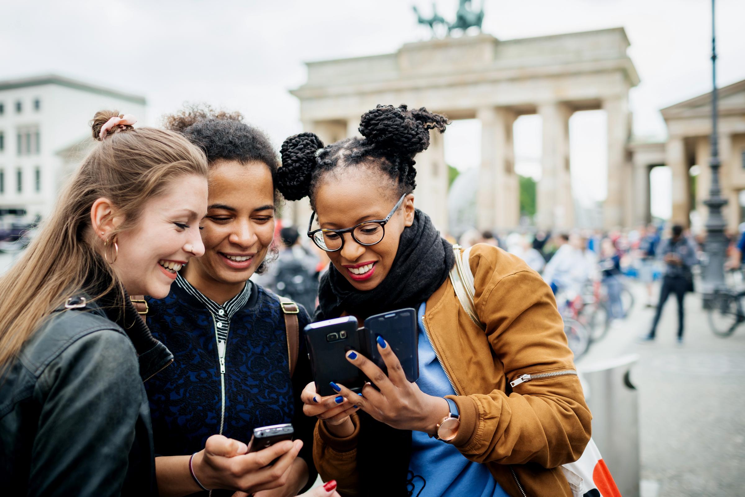 Un grupo de amigas viendo algo en sus teléfonos | Fuente: Getty Images