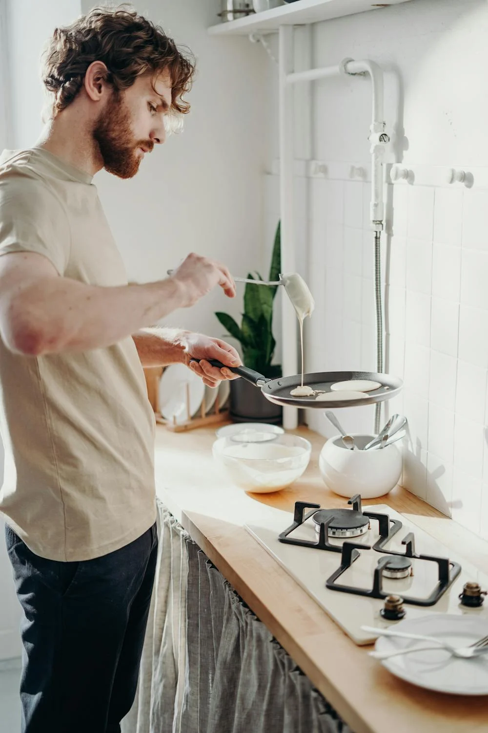 Un hombre horneando tortitas | Fuente: Pexels