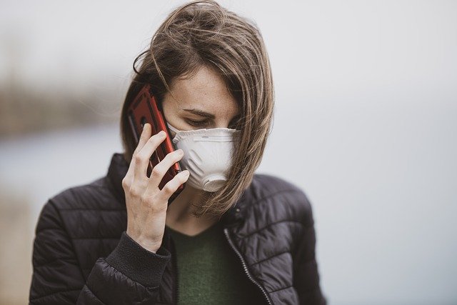 Mujer usando mascarilla mientras habla por teléfono. | Foto: Pixabay