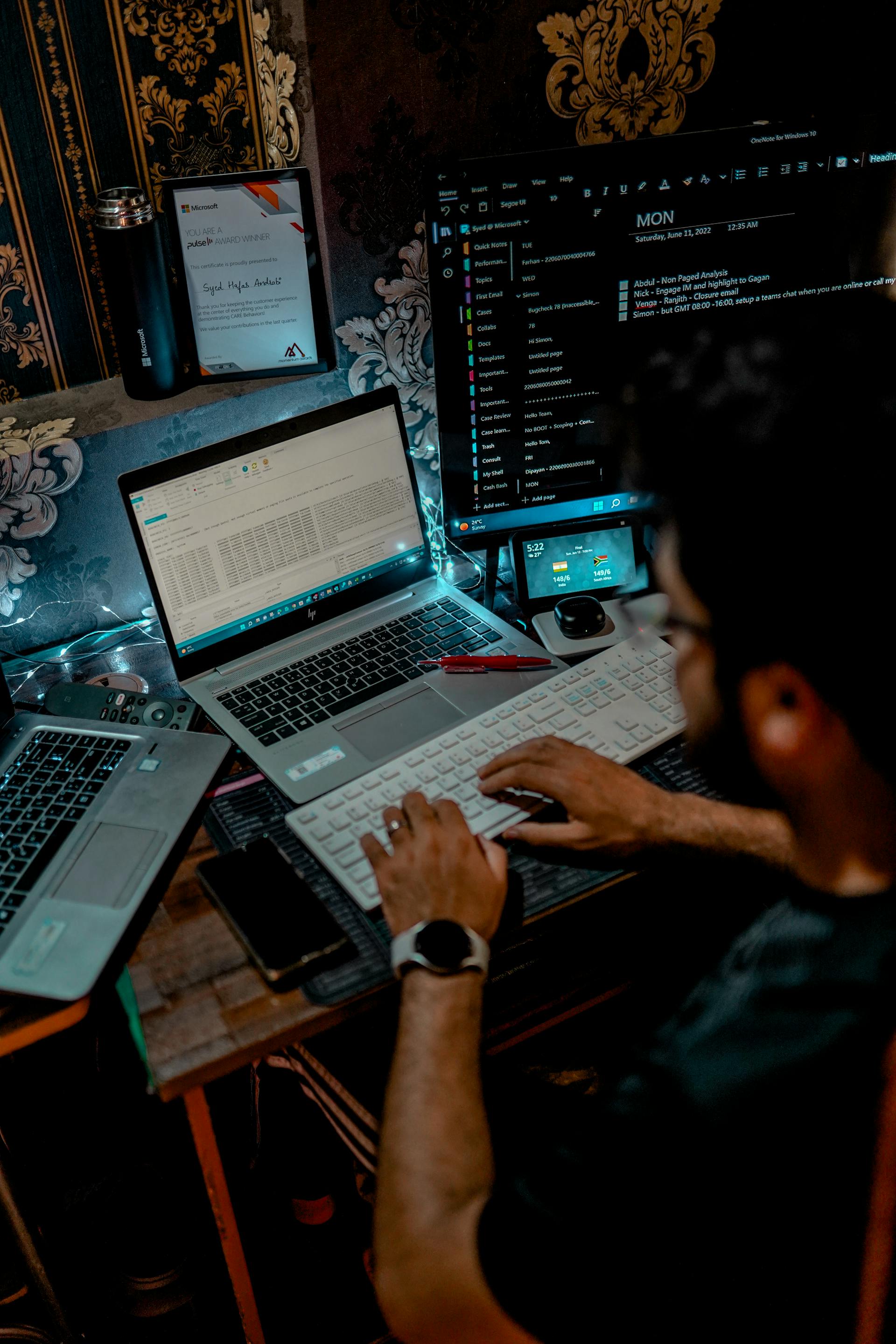 Un hombre trabajando con el teclado de un ordenador frente a un portátil | Fuente: Pexels