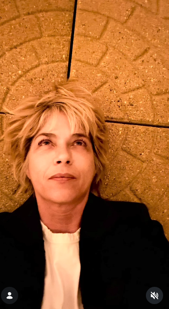 Selma Blair está recostada contra una superficie de piedra con un arco ornamentado, mirando pensativa hacia el techo el 11 de octubre de 2026. Una luz suave ilumina su pelo rubio y la chaqueta negra informal a medida que lleva puesta sobre una sencilla camiseta blanca. | Fuente: Instagram/selmablair