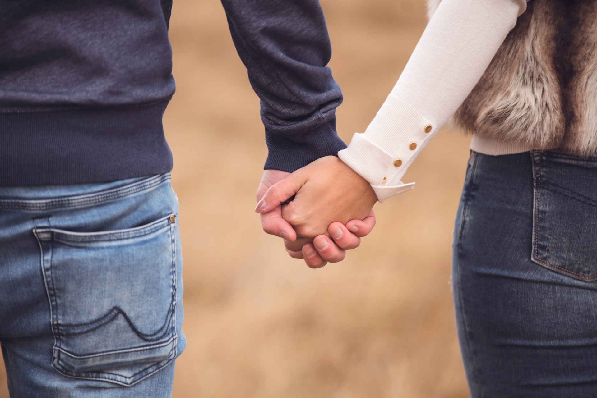 Foto recortada de una pareja tomada de la mano | Fuente: Unsplash