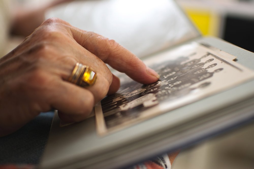 Mujer señalando una fotografía en un album. | Foto: Shutterstock