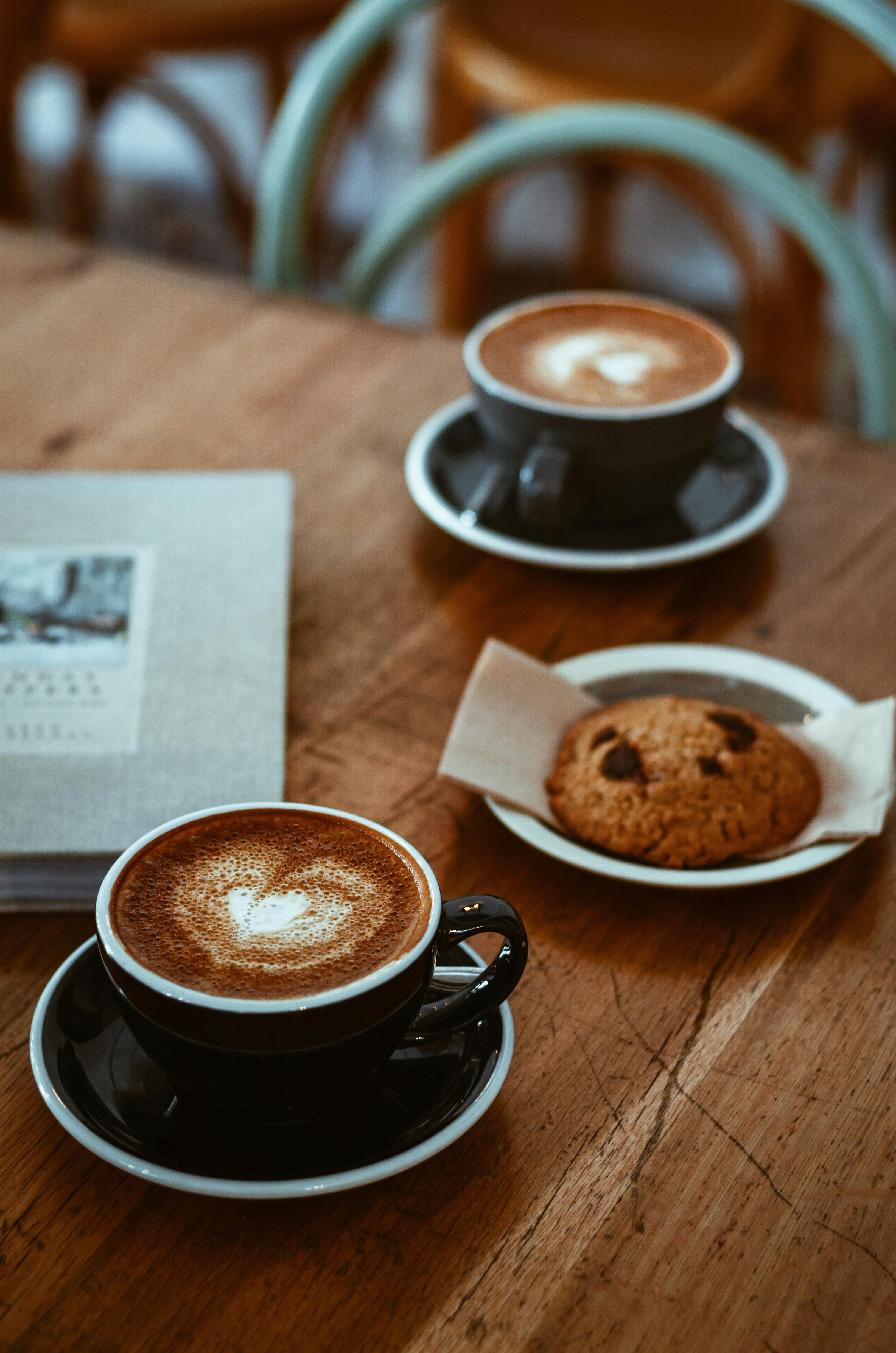 Dos tazas de café y una galleta | Fuente: Pexels