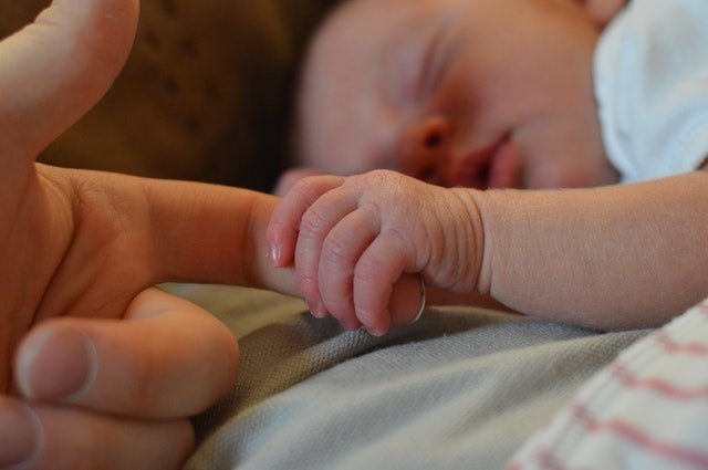 Bebé sosteniendo un dedo. | Foto: Pexels
