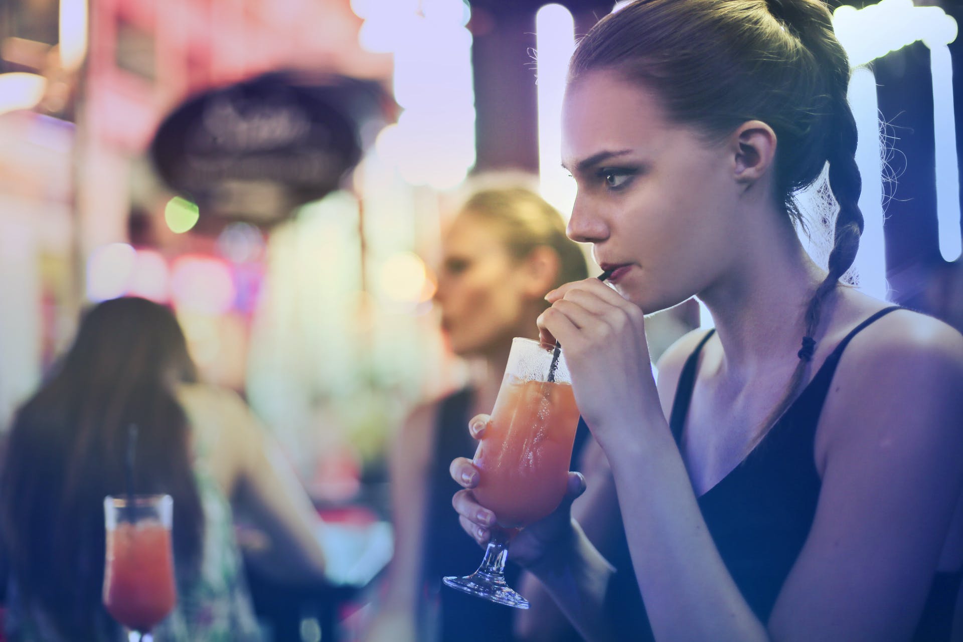 Mujer bebiendo un cóctel | Foto: Pexels