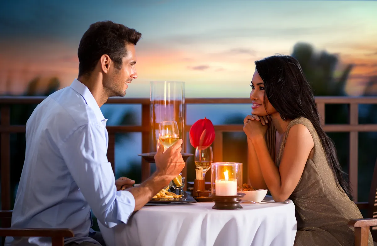 Una pareja feliz en una noche de verano cenando románticamente al aire libre | Foto: Shutterstock