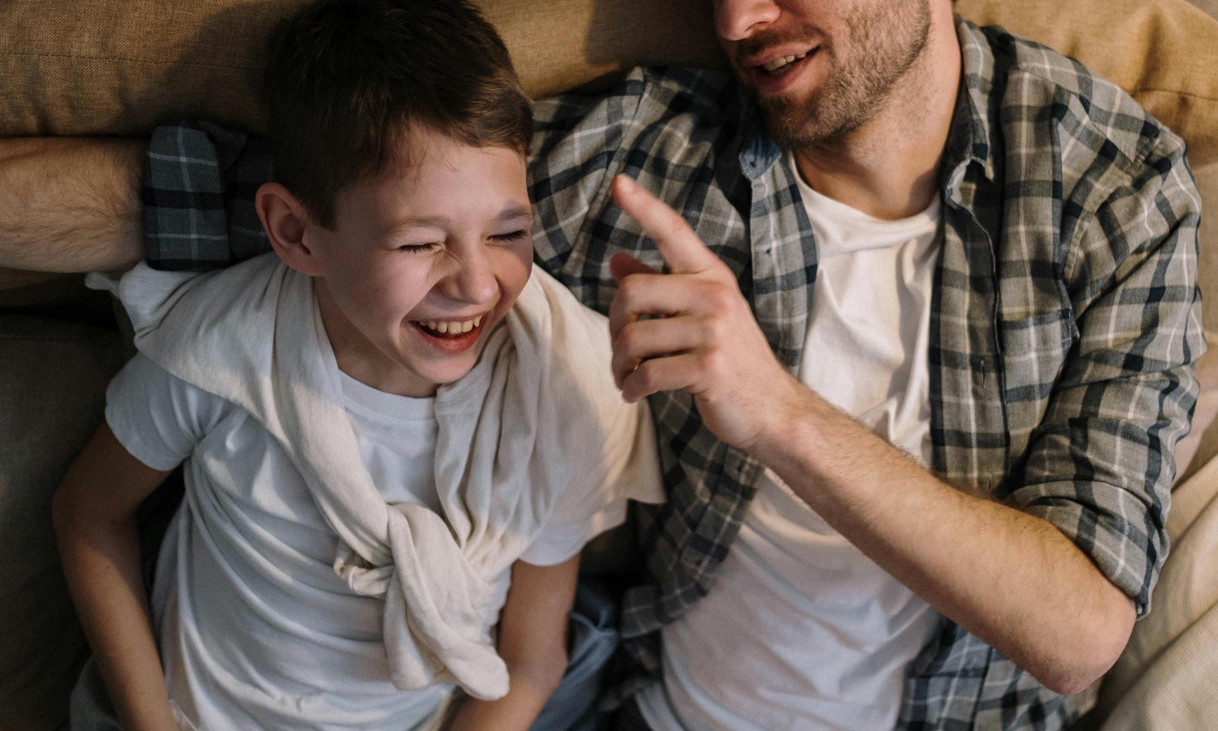 Un hombre y un niño riendo juntos | Fuente: Pexels