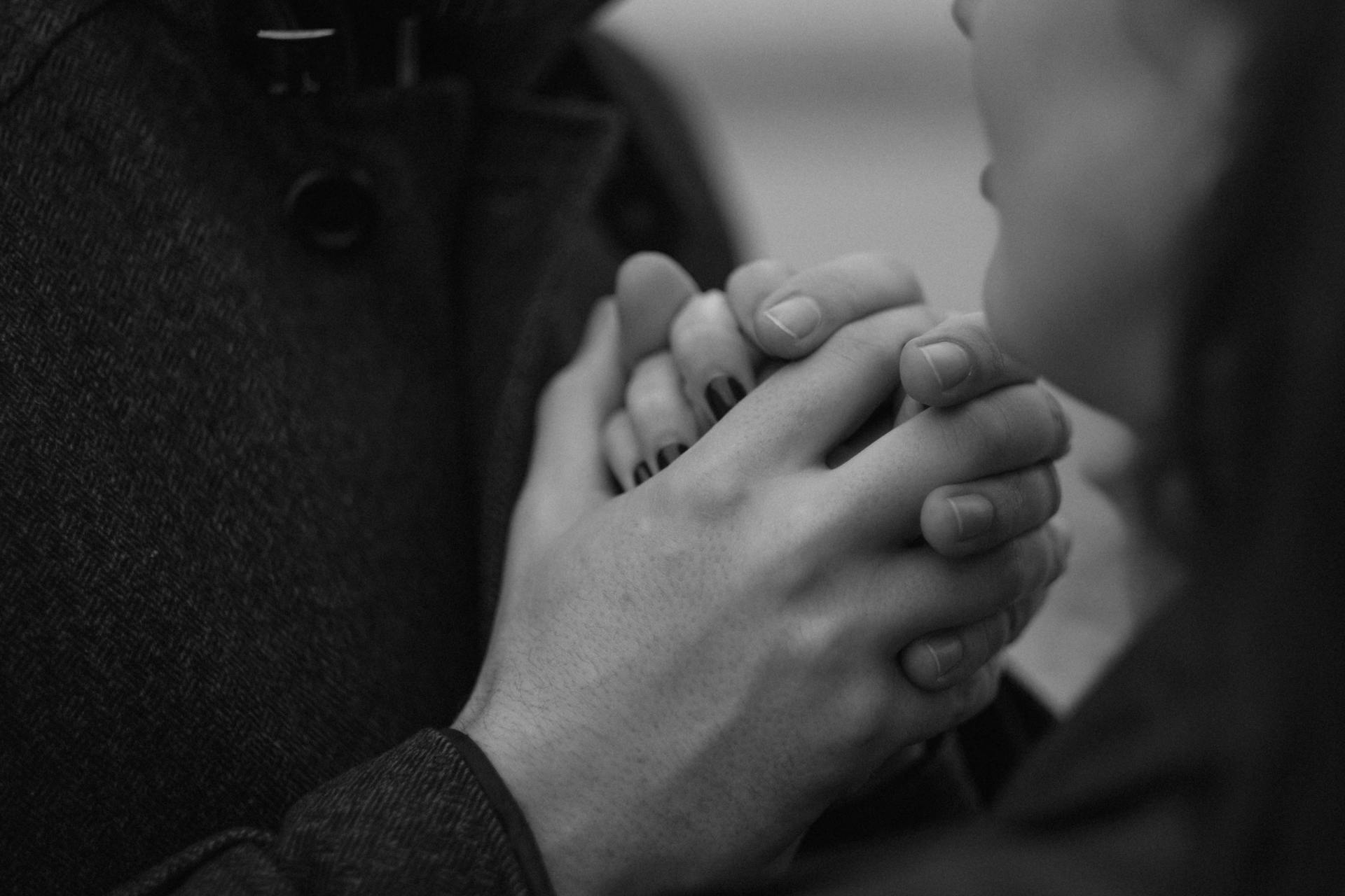 Scatto in scala di grigi di una coppia che si tiene per mano | Fonte: Pexels