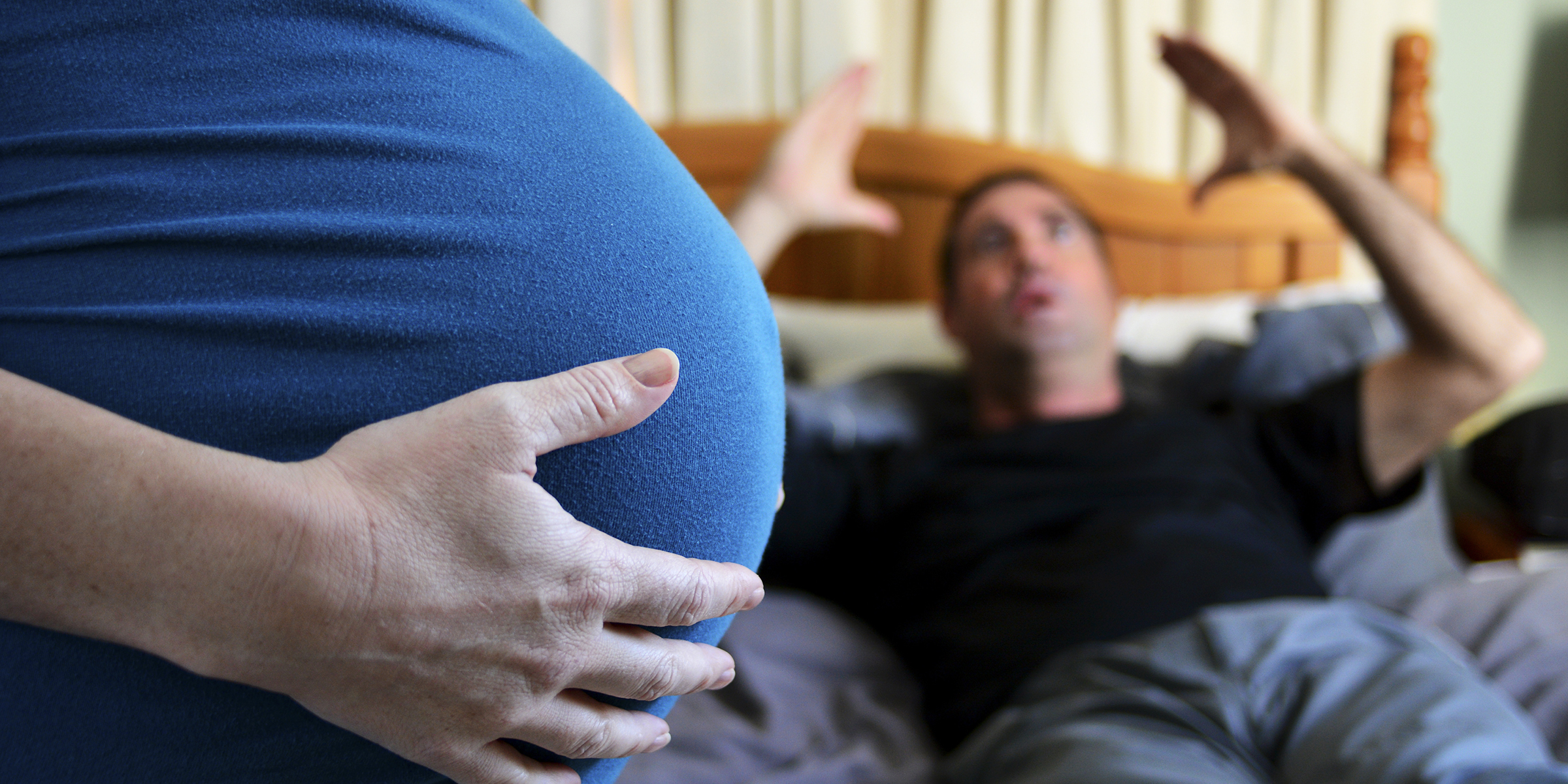 Una mujer embarazada con un hombre enfadado al fondo | Foto: Shutterstock