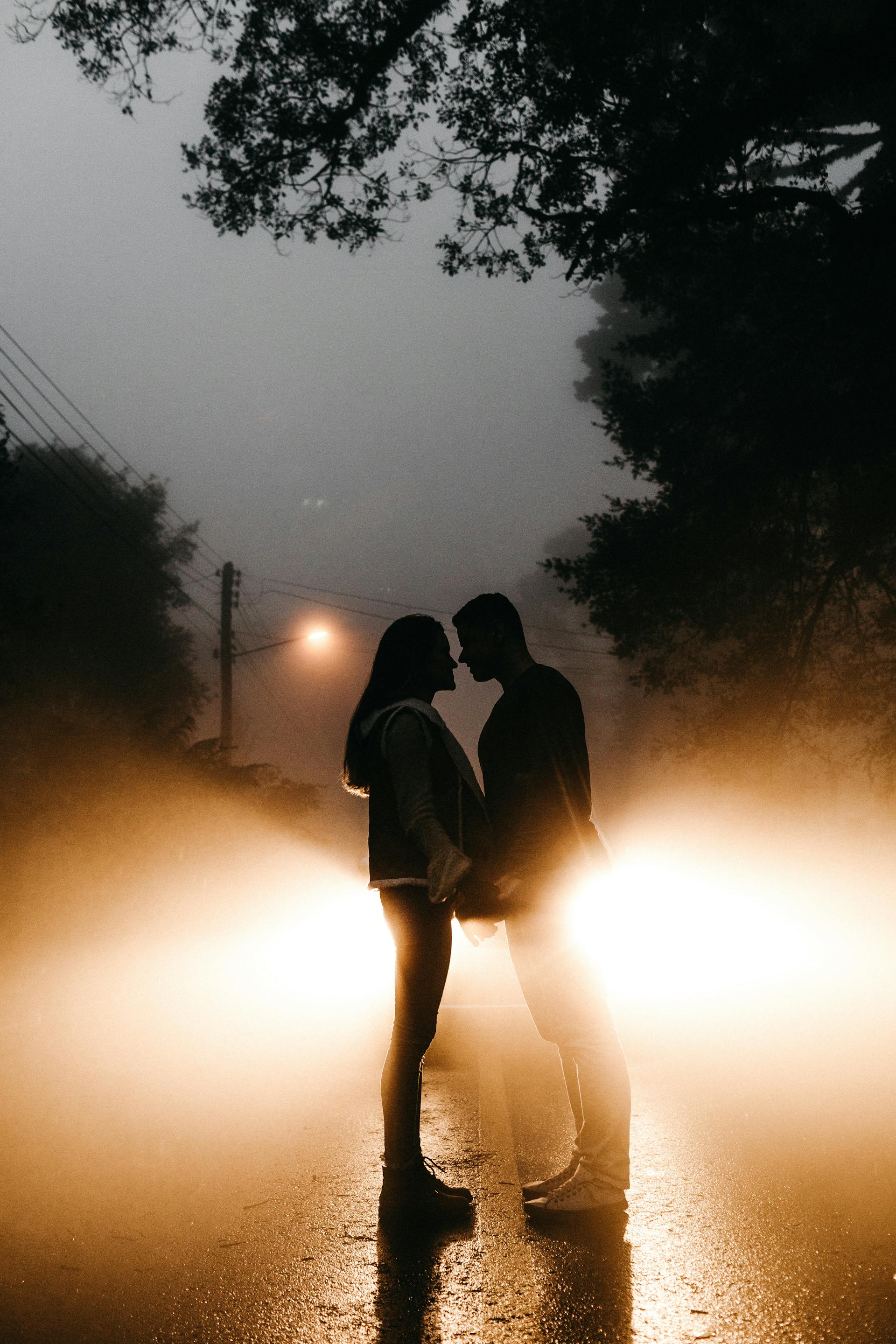 Un plano lejano de una pareja de pie en la carretera mientras se toman las manos | Fuente: Pexels