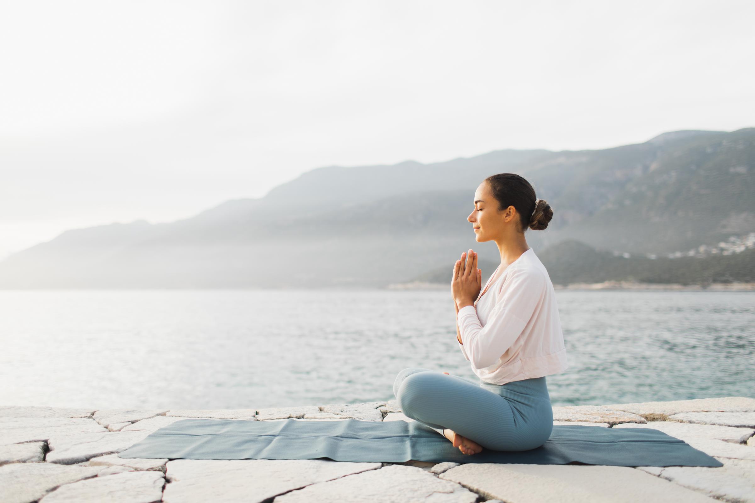 Mujer practicando yoga al aire libre | Fuente: Getty Images
