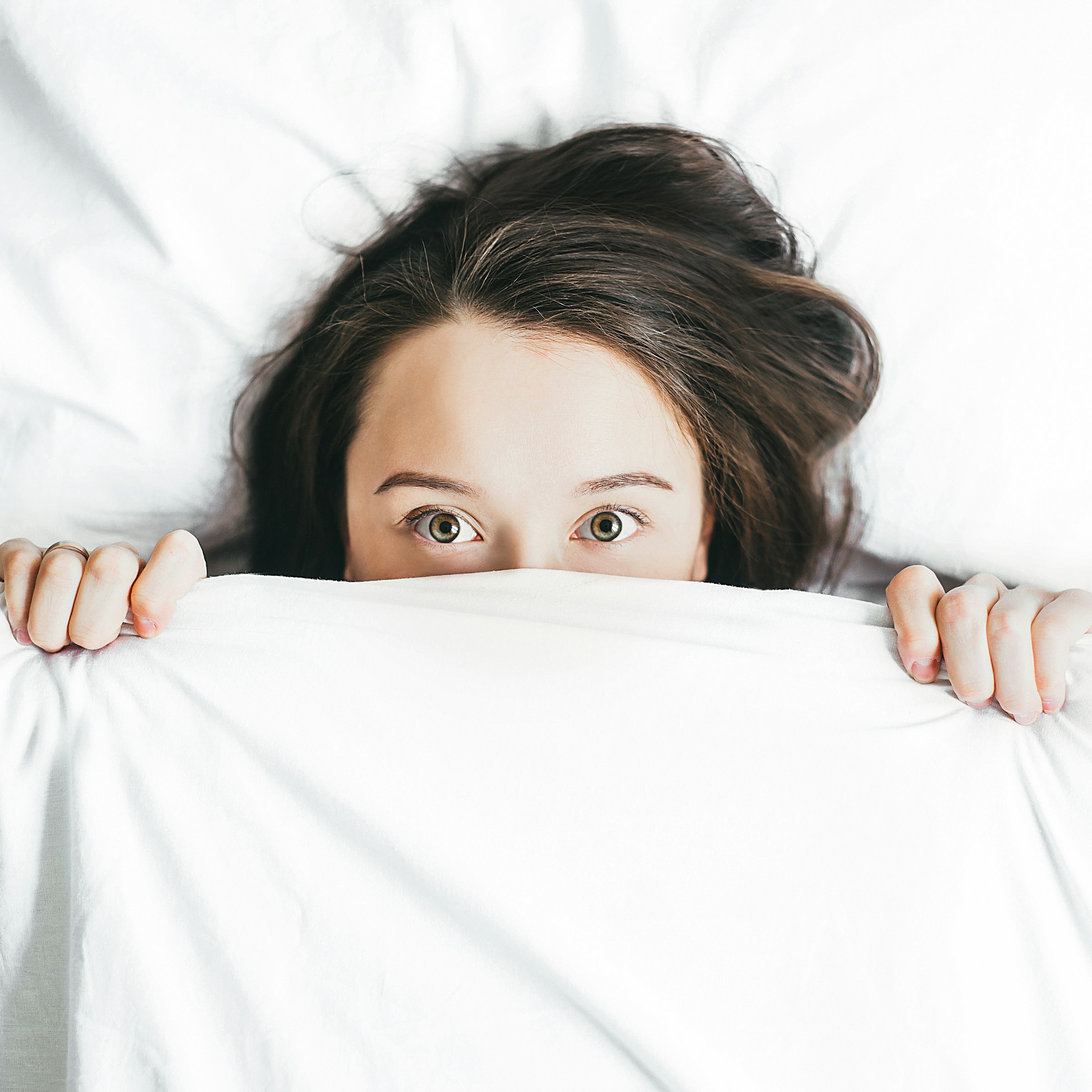 Una mujer en la cama con los ojos muy abiertos | Fuente: Unsplash