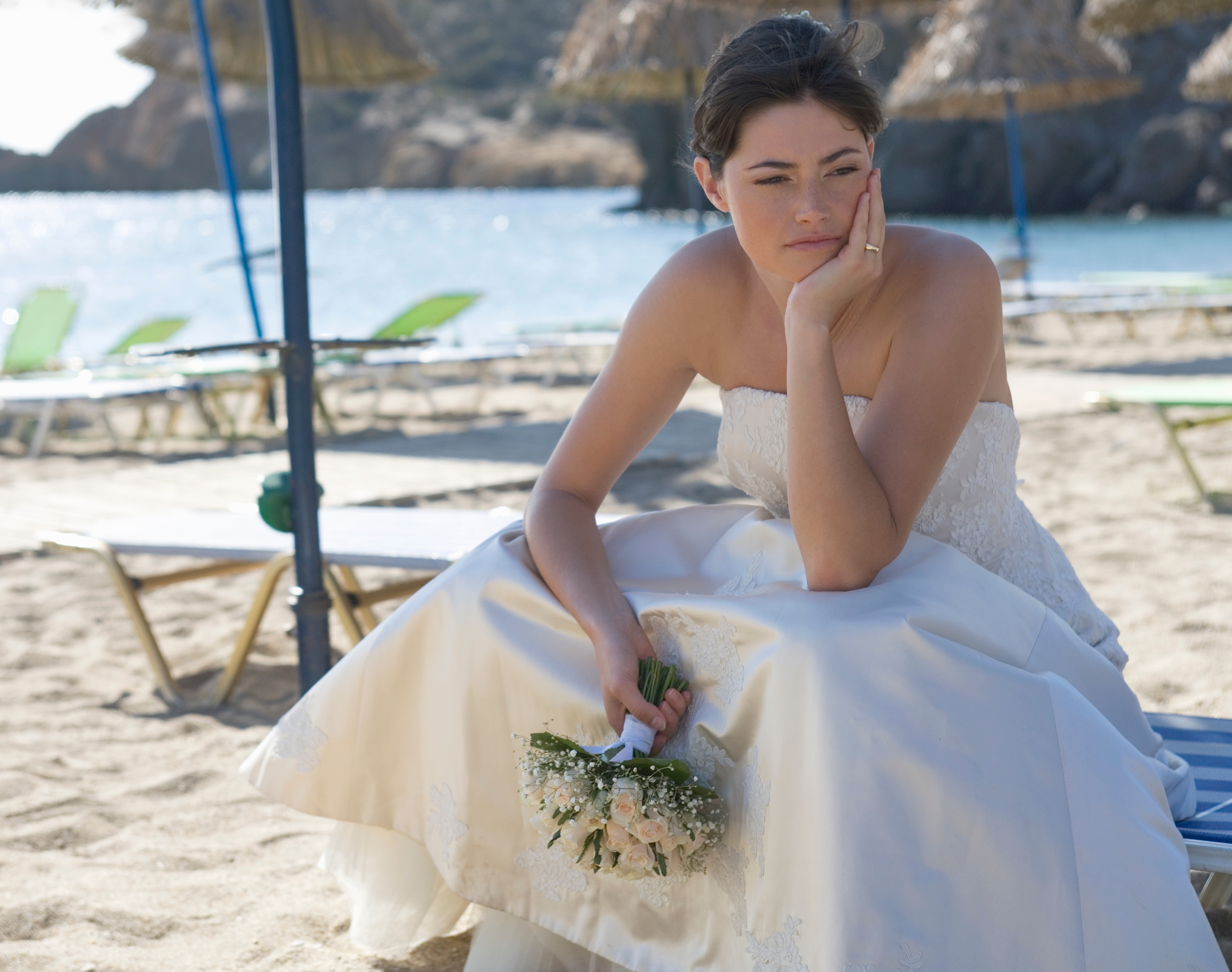 Una novia infeliz aparece sentada en una playa | Foto: Shutterstock