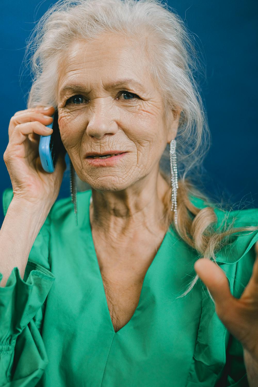 Una mujer con un vestido verde hablando por teléfono | Fuente: Pexels