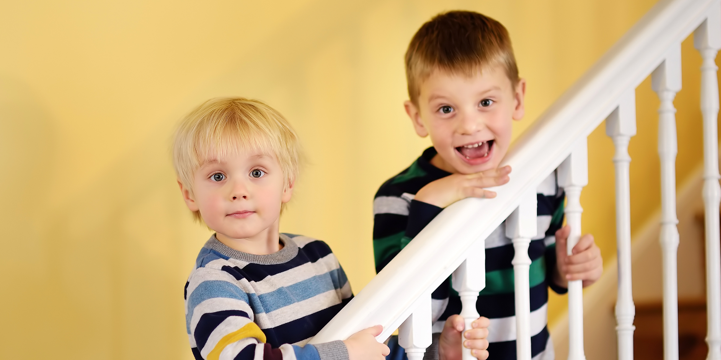 Dos chicos de pie en una escalera | Fuente: Shutterstock