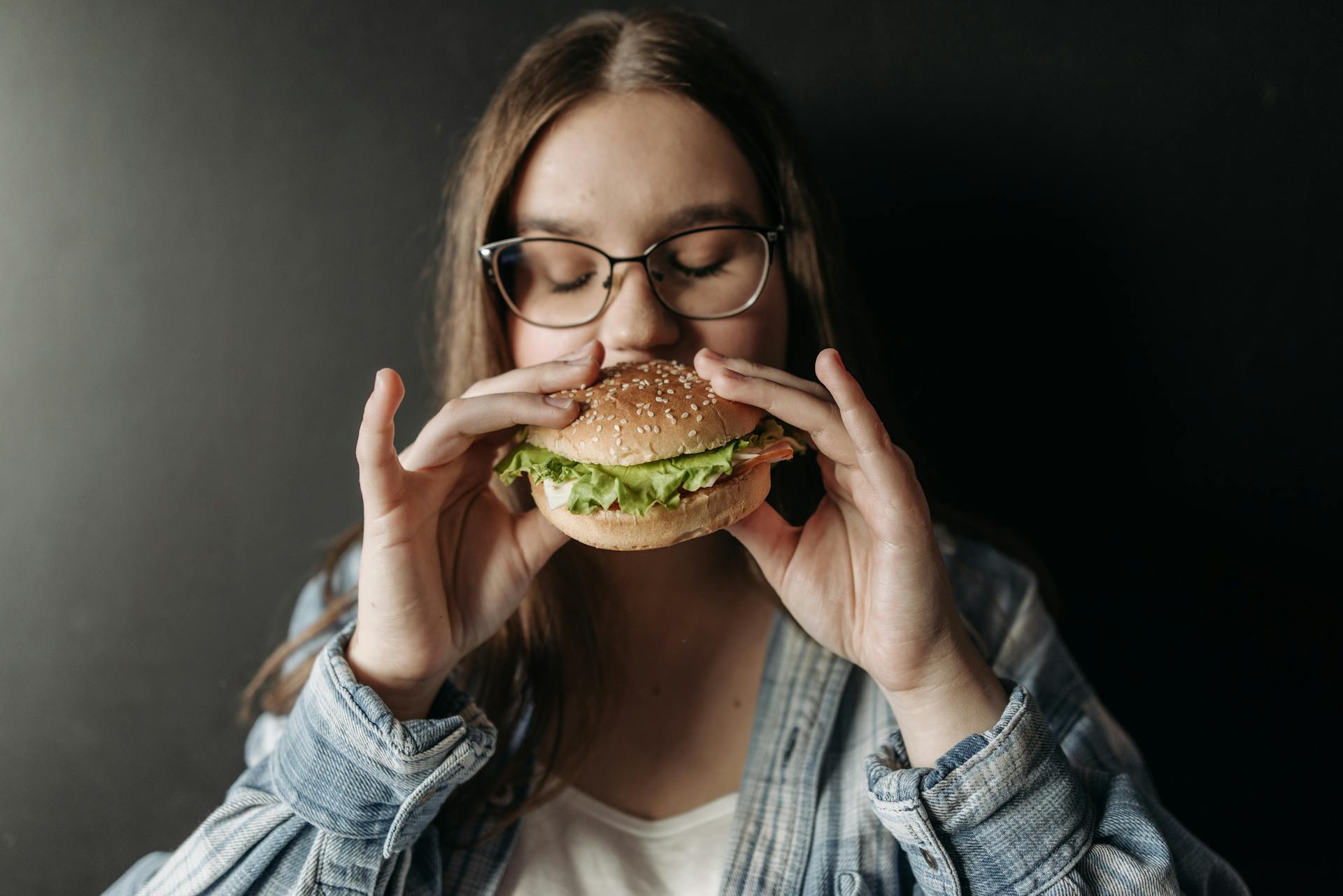 Una mujer comiendo hamburguesa | Fuente: Pexels