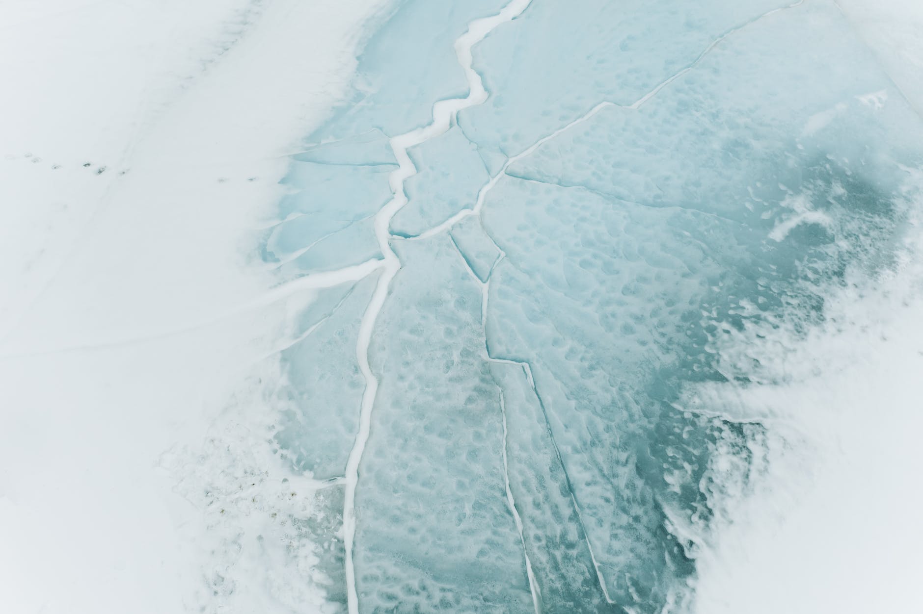 El hielo de un lago congelado agrietándose. | Foto: Pexels
