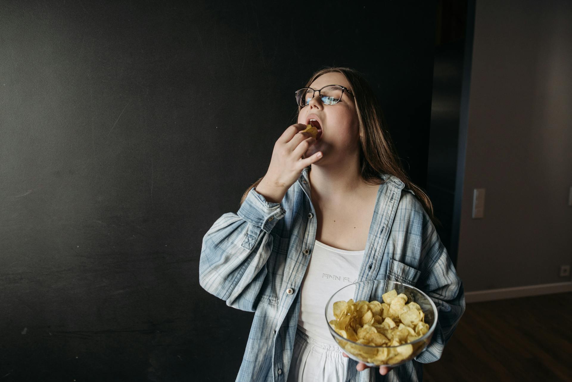 Una mujer comiendo patatas fritas | Fuente: Pexels