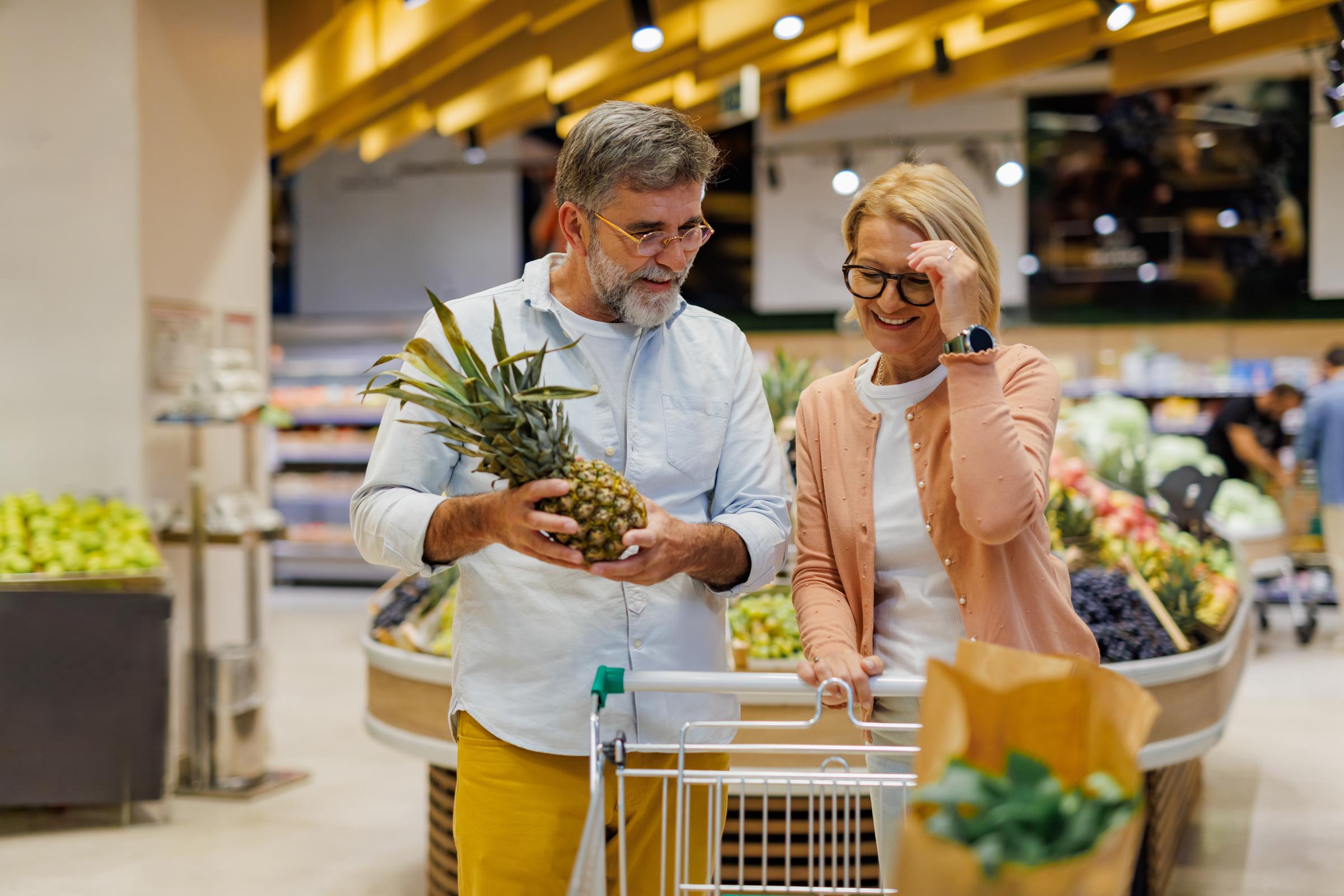Una pareja en la sección de frutas y verduras de un supermercado | Fuente: Shutterstock