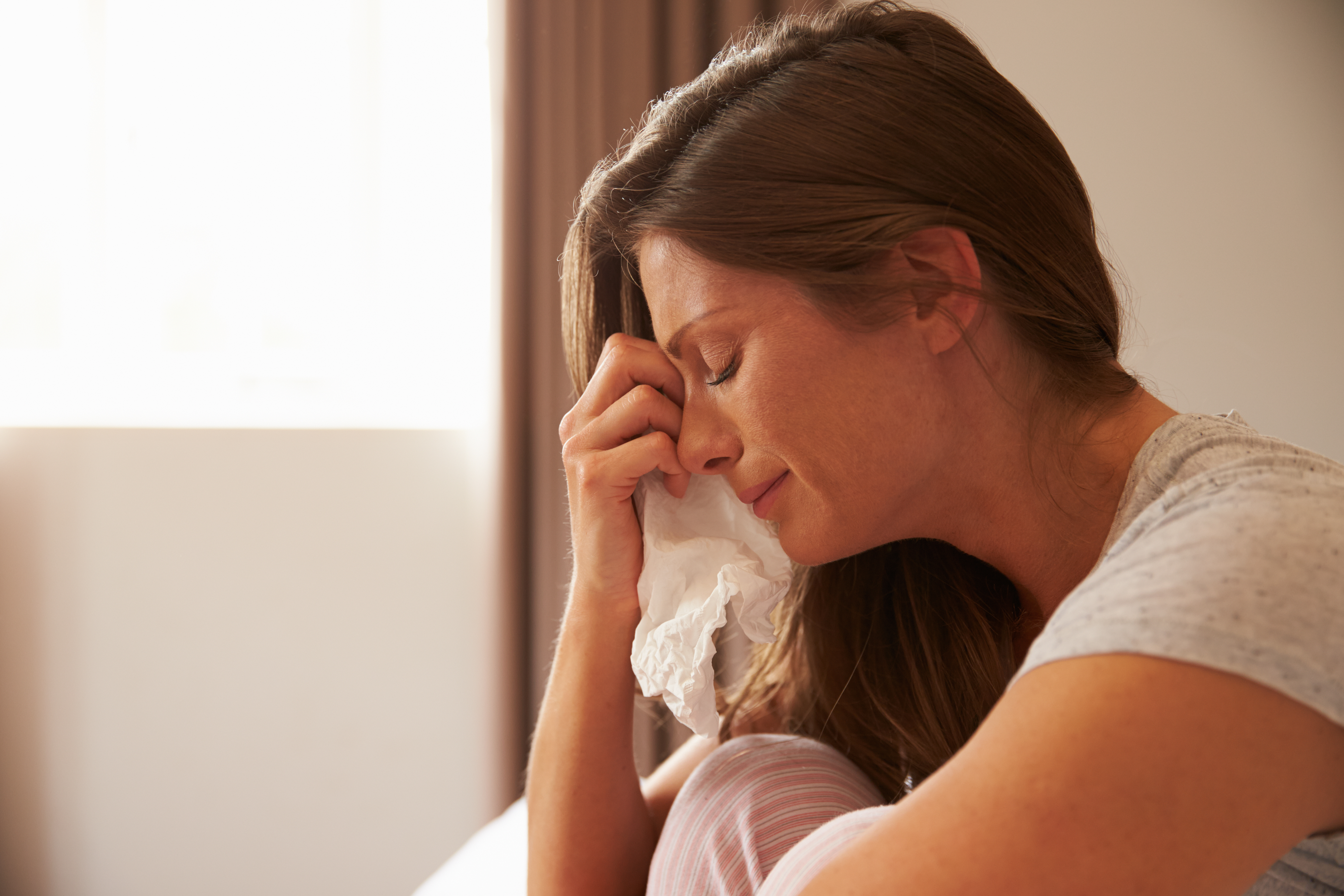 Mujer con un pañuelo llorando | Foto: Shutterstock