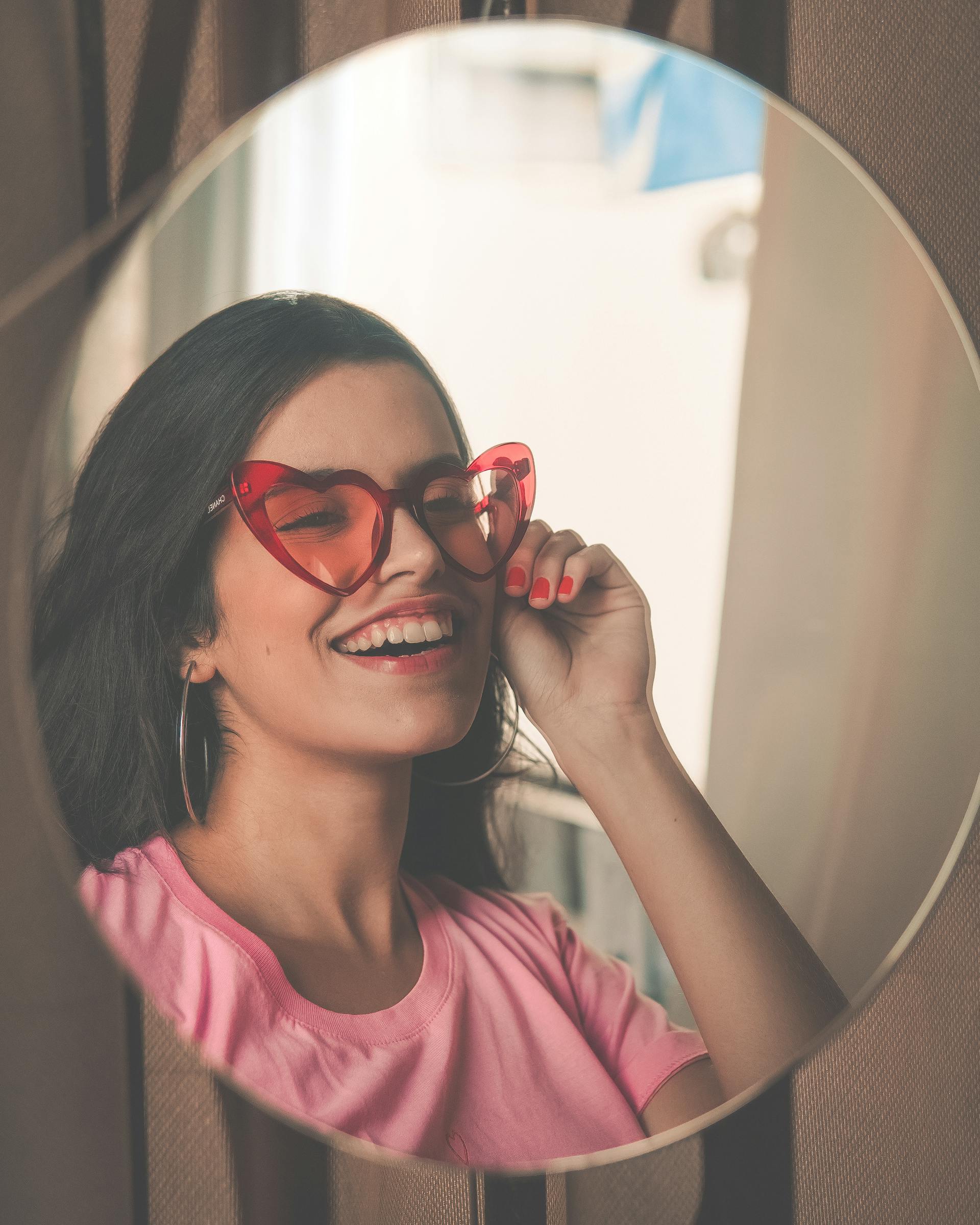 Una mujer sonriendo en un espejo | Fuente: Pexels