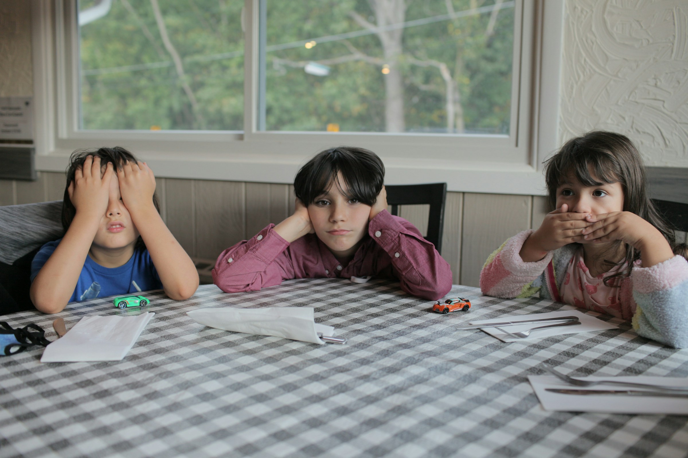 Tres niños sentados en una mesa | Fuente: Unsplash