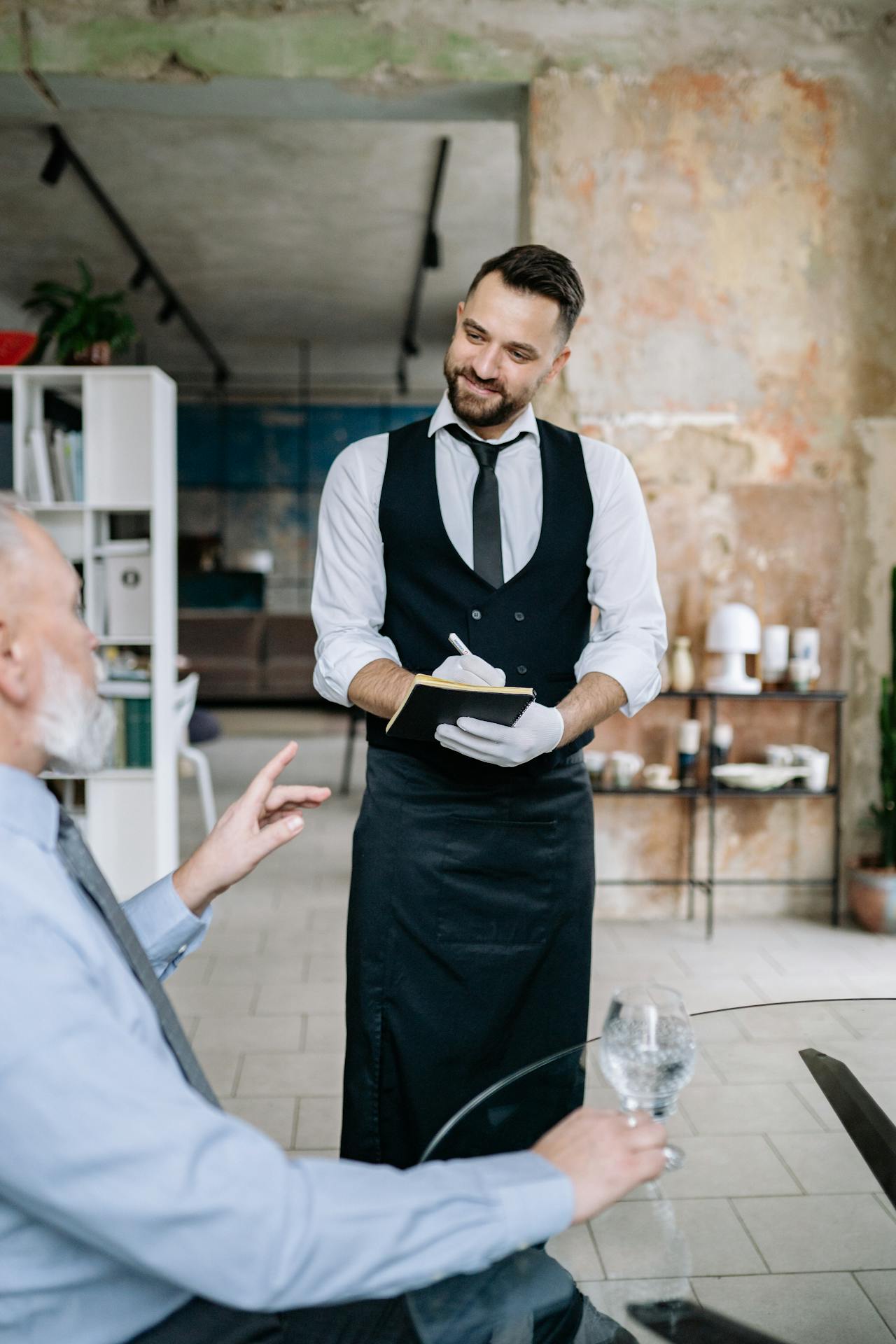 Un camarero tomando el pedido de un cliente en un restaurante | Fuente: Pexels
