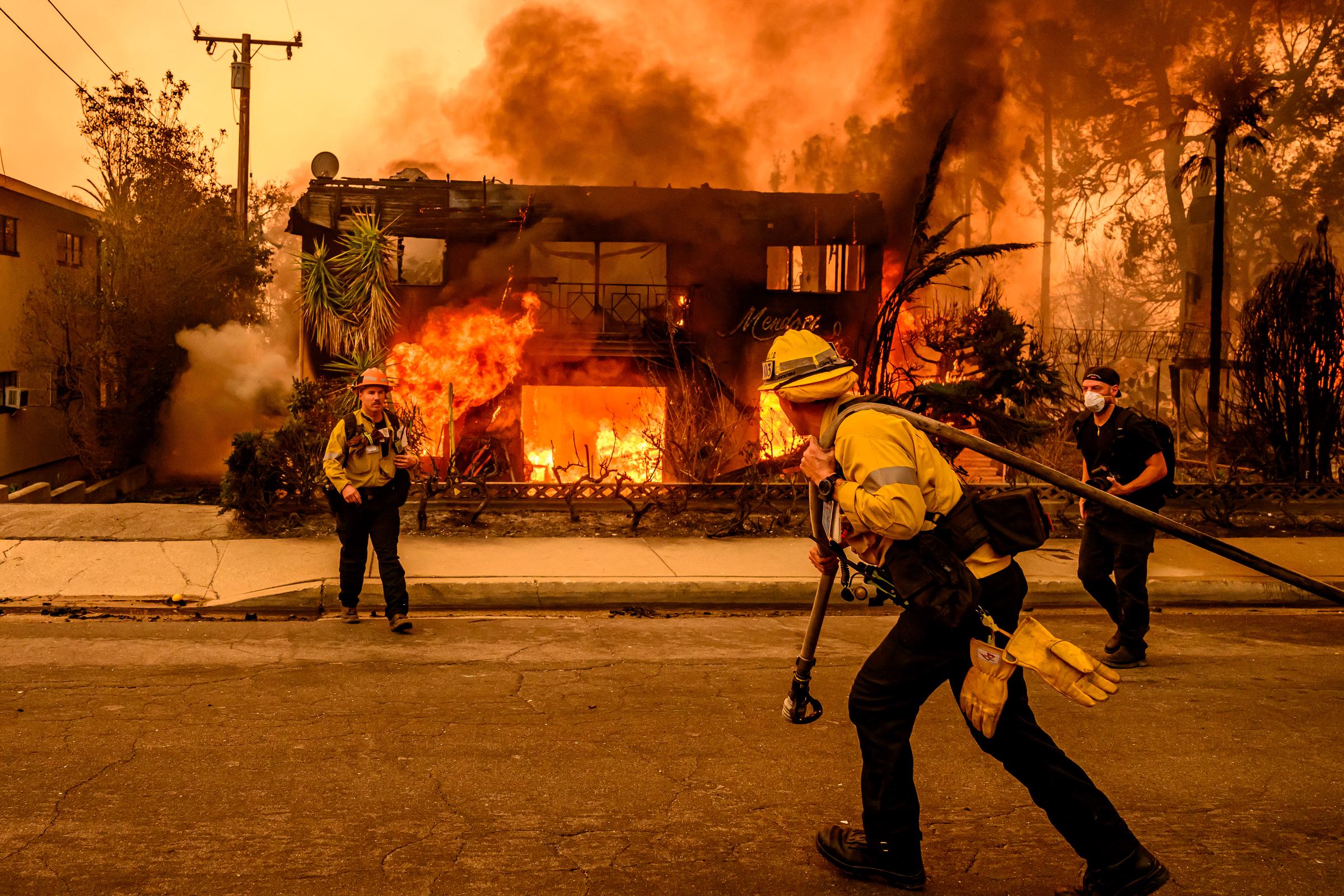 Los bomberos trabajan en la escena mientras arde un edificio de apartamentos durante el incendio de Eaton en la zona de Altadena, condado de Los Ángeles, California, el 8 de enero de 2025 | Fuente: Getty Images