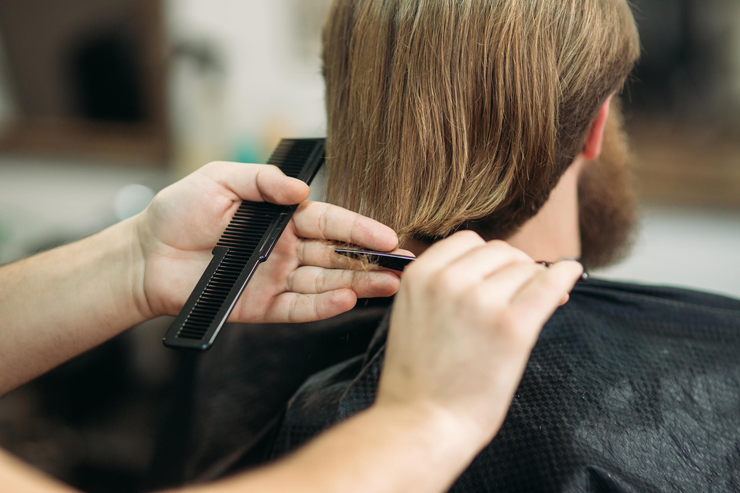 Una persona che si fa tagliare i capelli | Fonte: Shutterstock