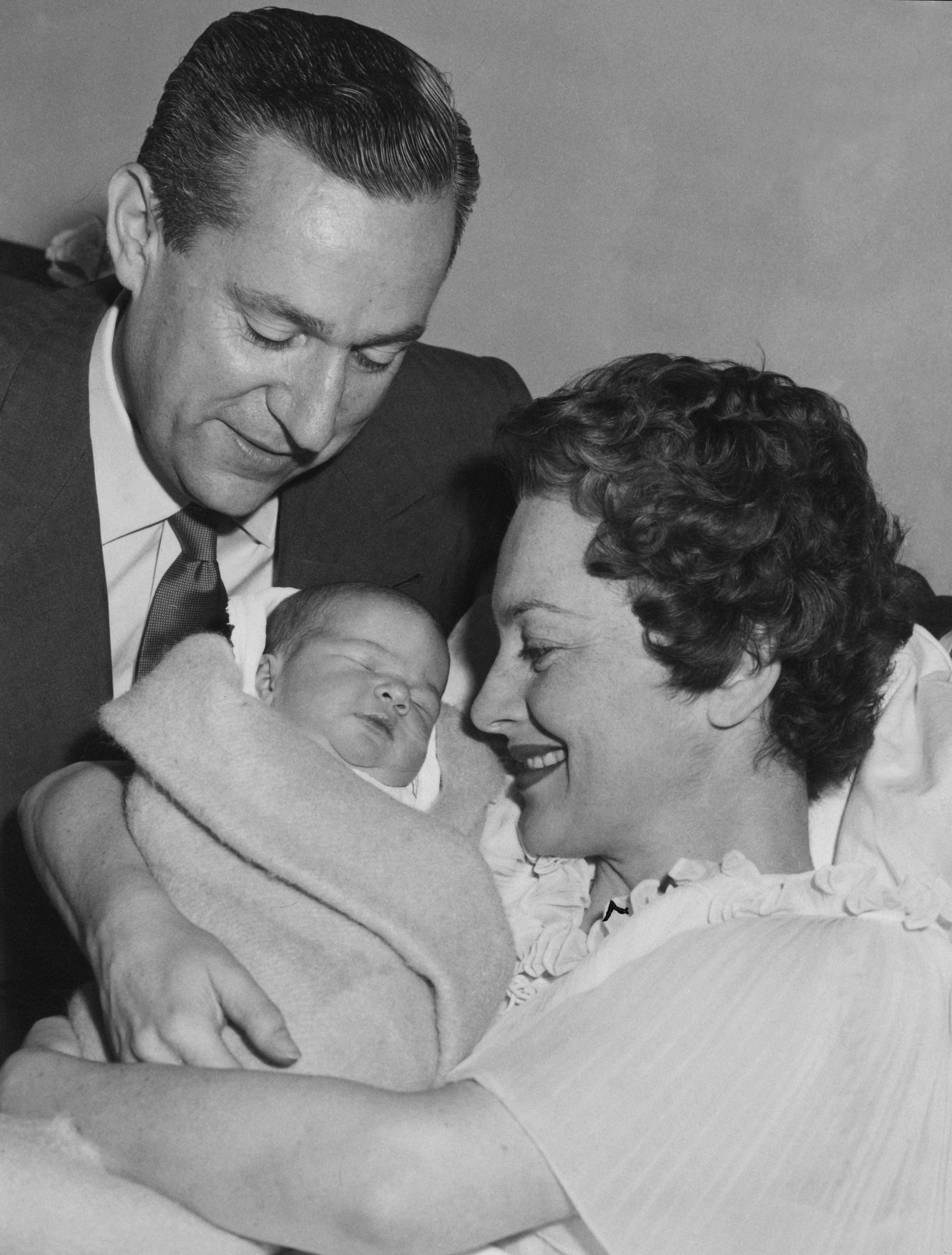 Olivia de Havilland y el periodista francés Pierre Galante con su hija, Gisèle, en el American Hospital en París, el 23 de julio de 1956. | Foto: Getty Images