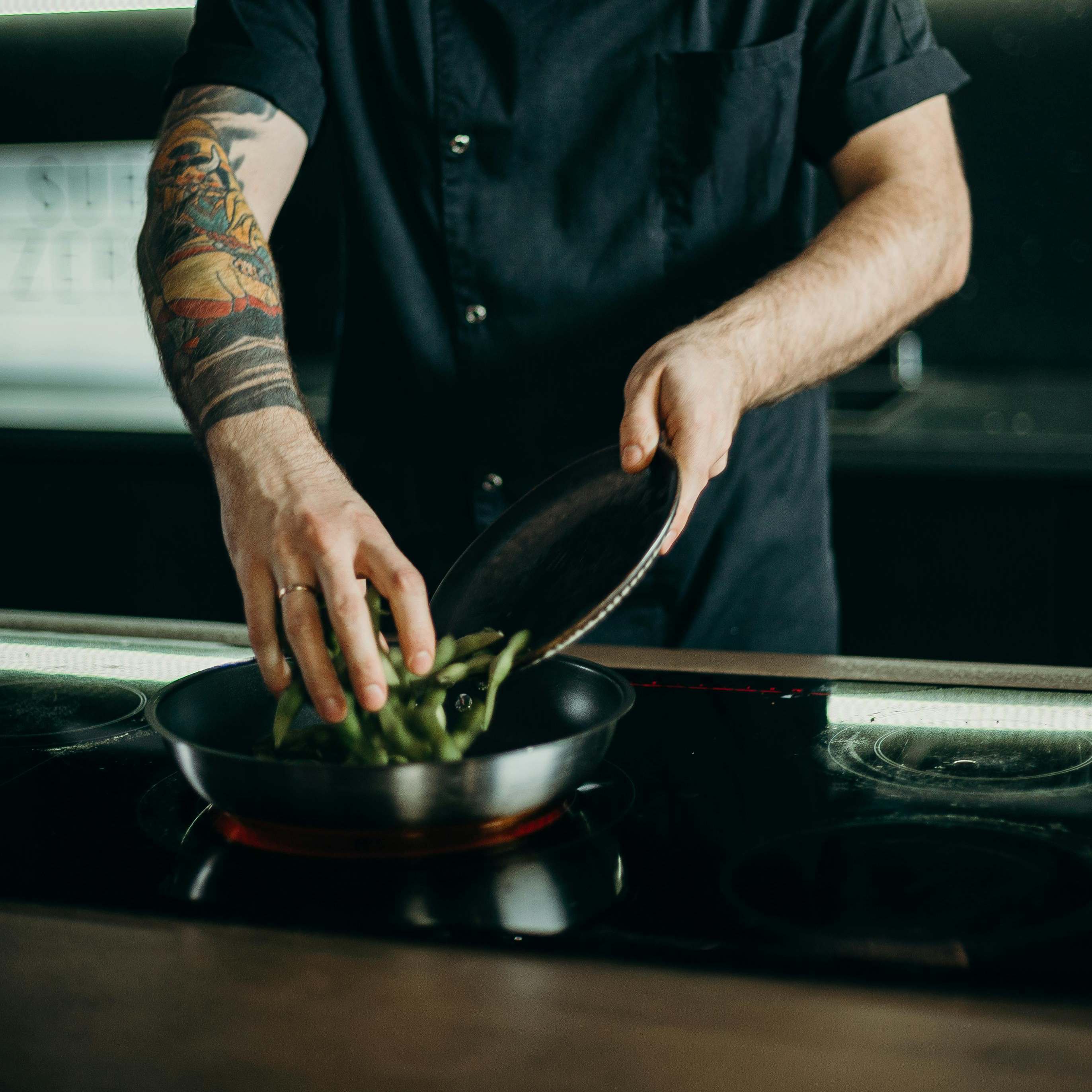 Un hombre calentando comida en una sartén | Fuente: Pexels