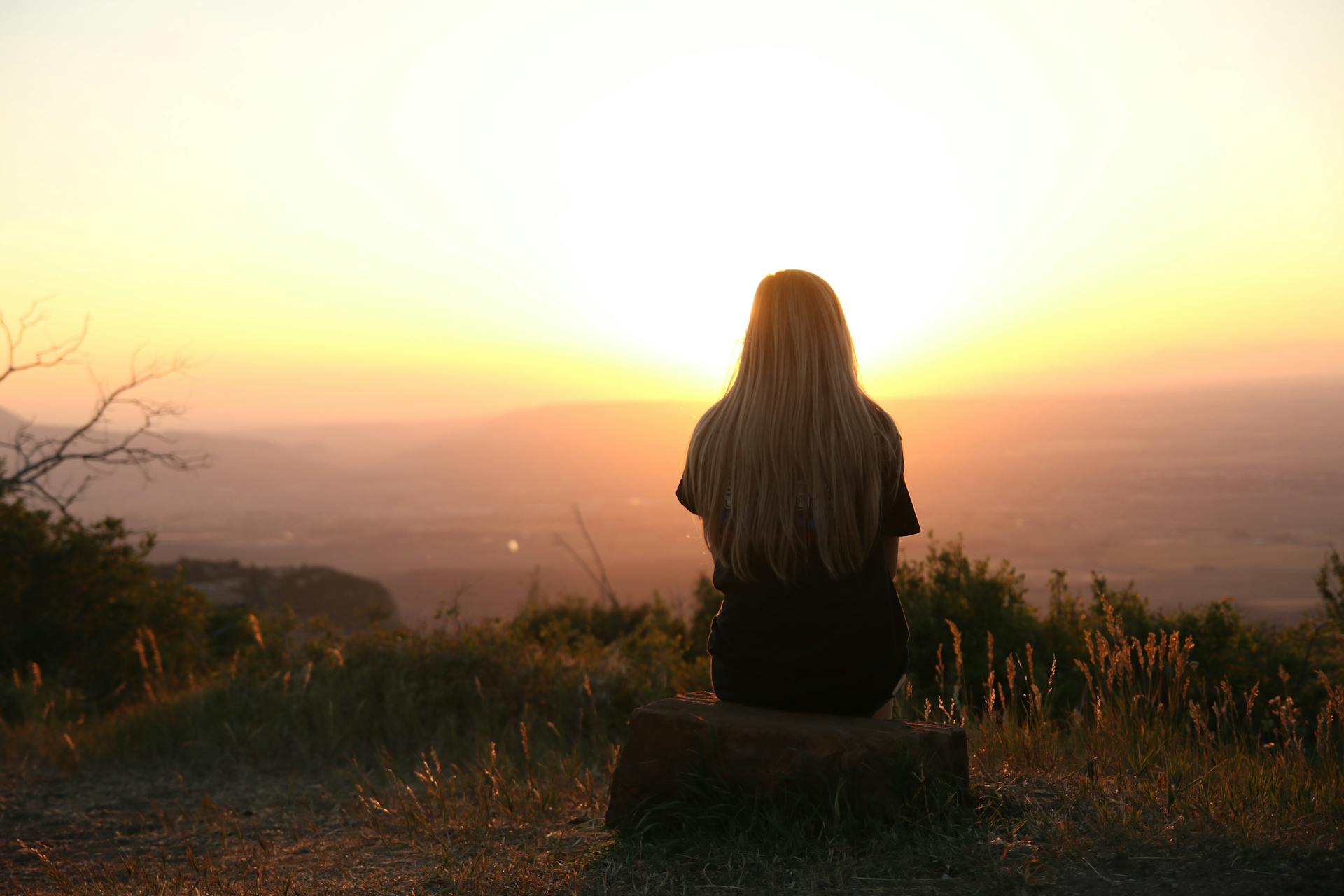 Mujer sentada en una montaña disfrutando de las vistas | Fuente: Pexels