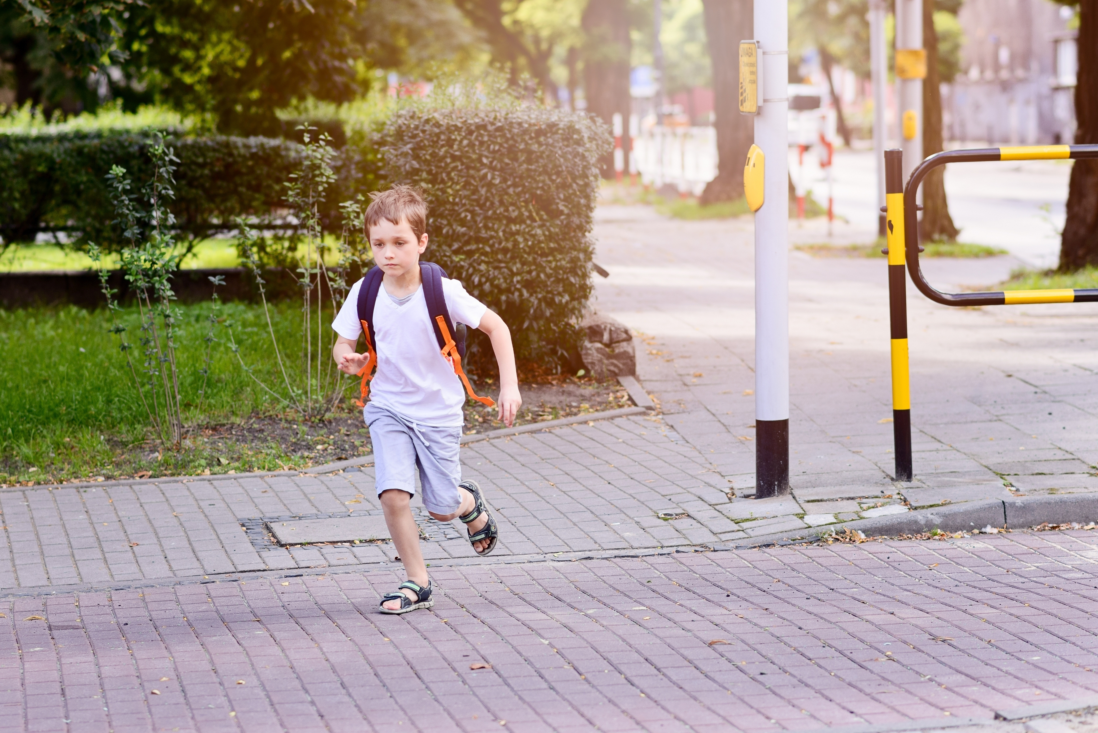 Pequeño escolar de 7 años corre por la calle | Fuente: Shutterstock.com