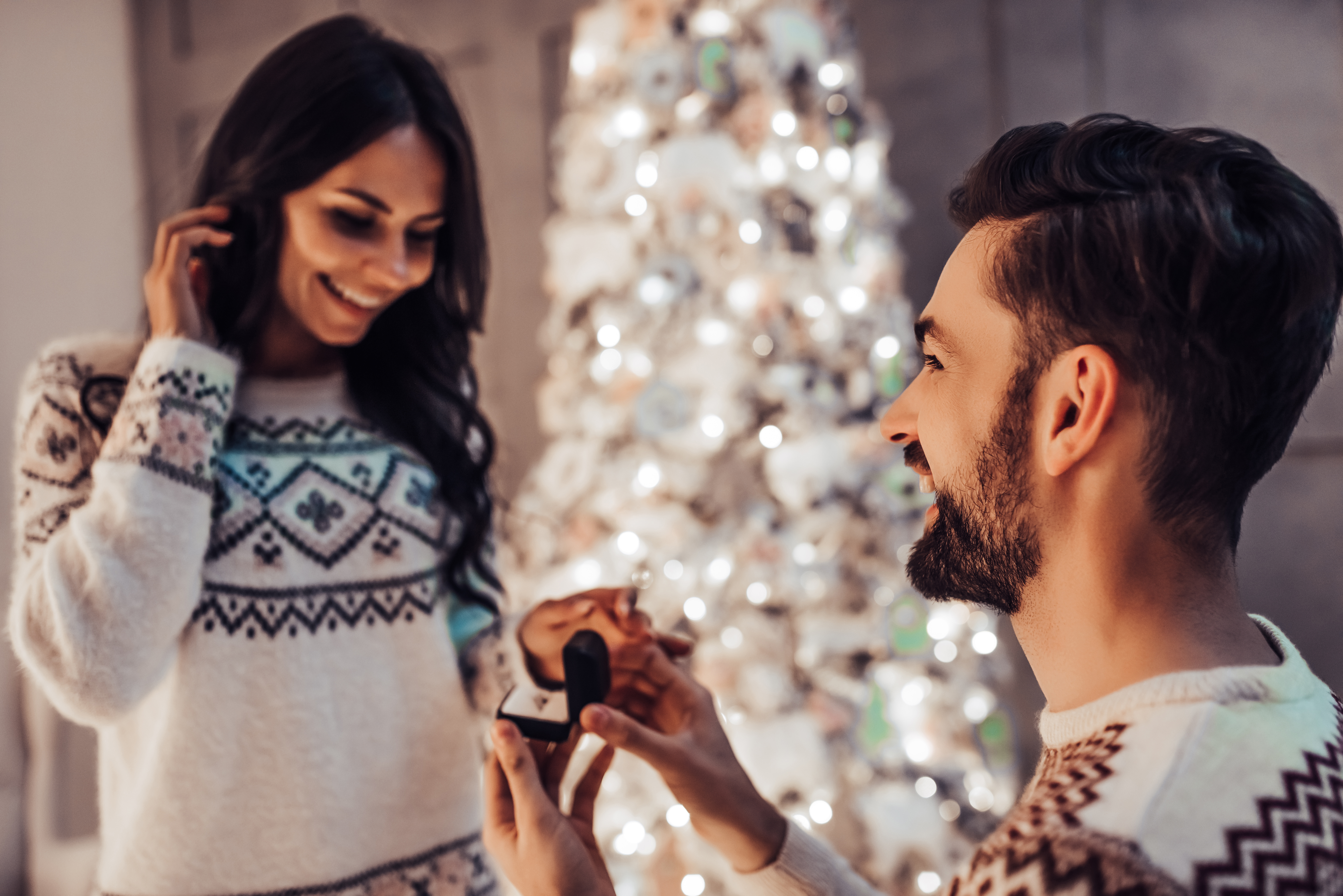 Un hombre pidiéndole matrimonio a su novia en Navidad | Fuente: Shutterstock