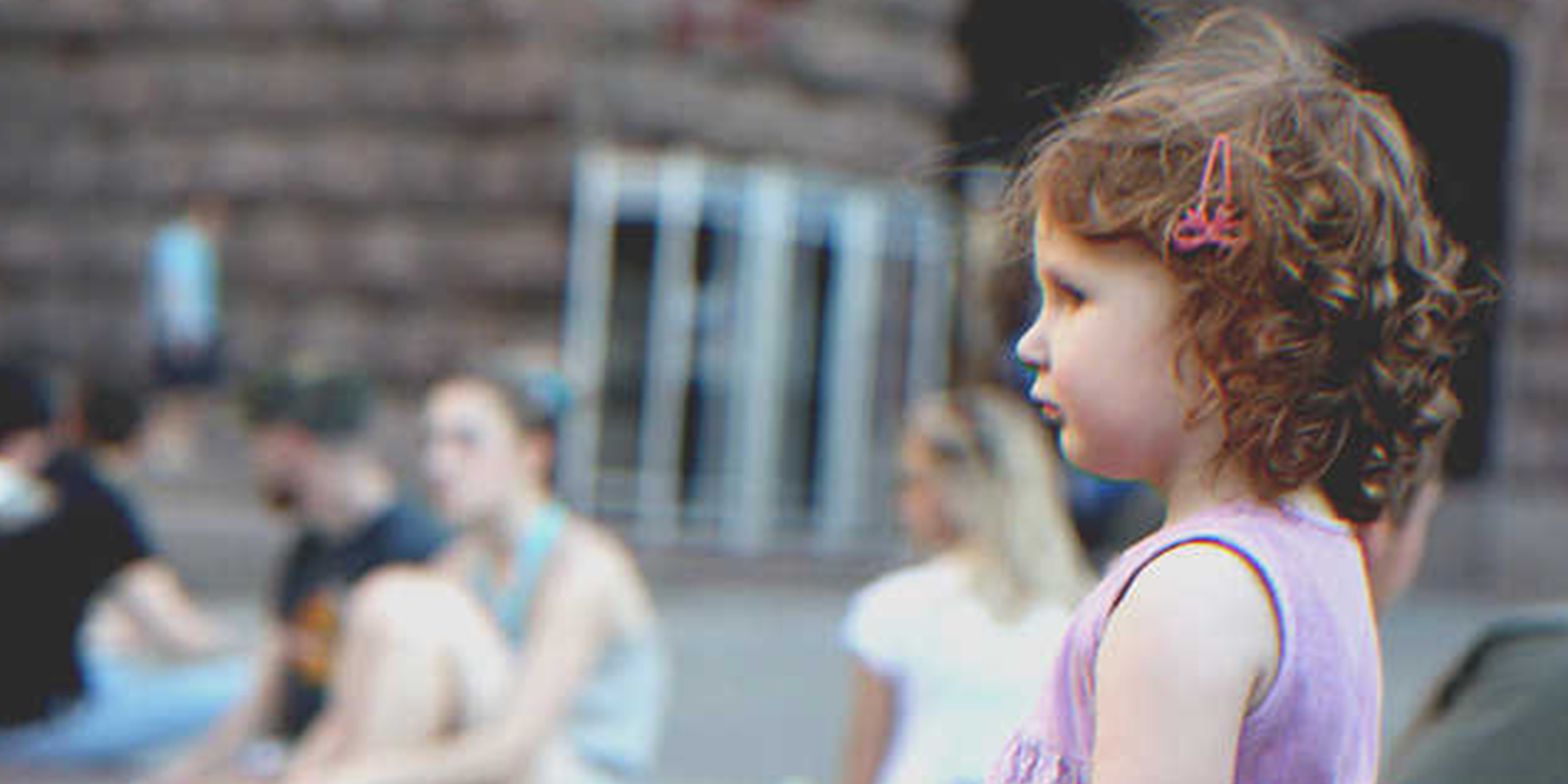 Una niña de pie cerca de varias personas. | Foto: Flickr.com/Roman Harak (CC BY-SA 2.0)