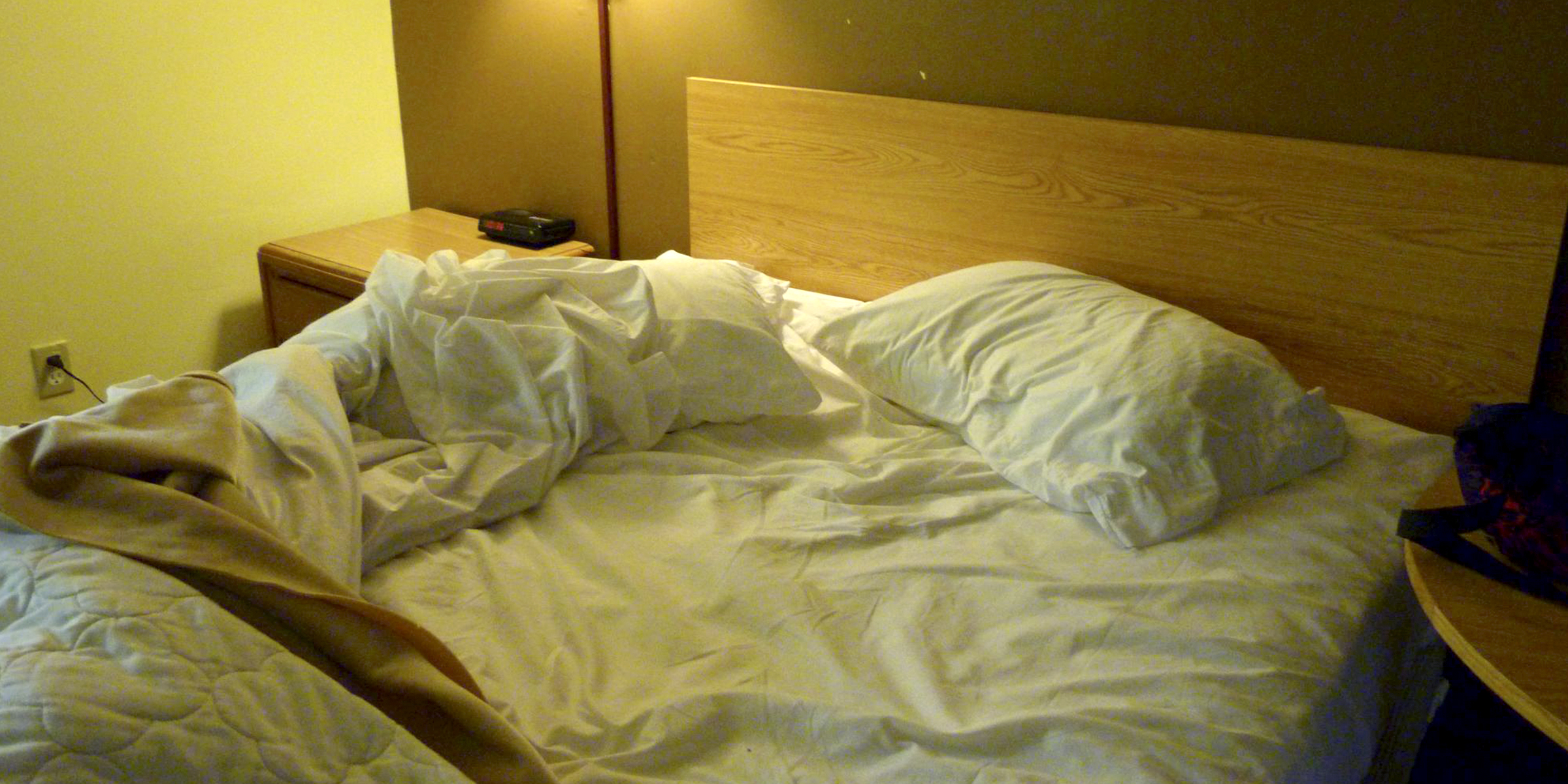 Una cama desordenada con sábanas y almohadas blancas. | Foto: Flickr.com/Rusty Clark (CC BY 2.0)