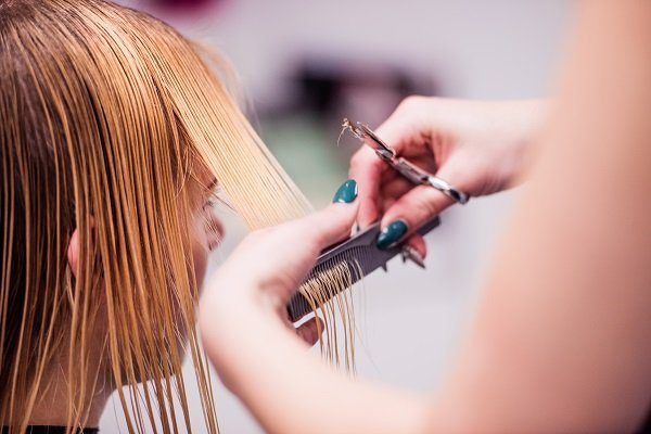 Mujer cortándose el cabello. Fuente: Shutterstock