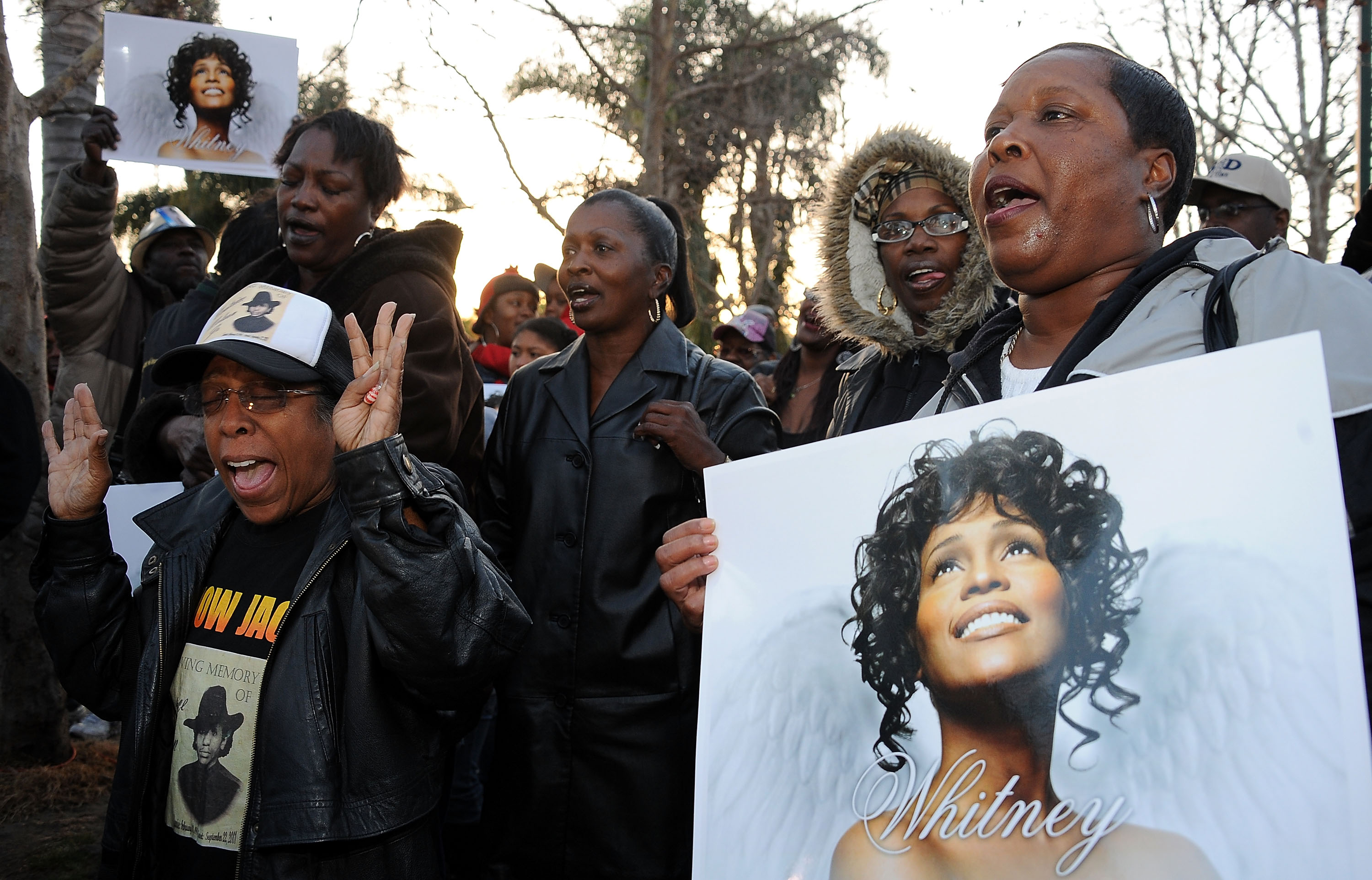 Fans sosteniendo carteles de Whitney Houston en su Vigilia de Leimert Park en Los Ángeles, California, el 13 de febrero de 2012 | Fuente: Getty Images