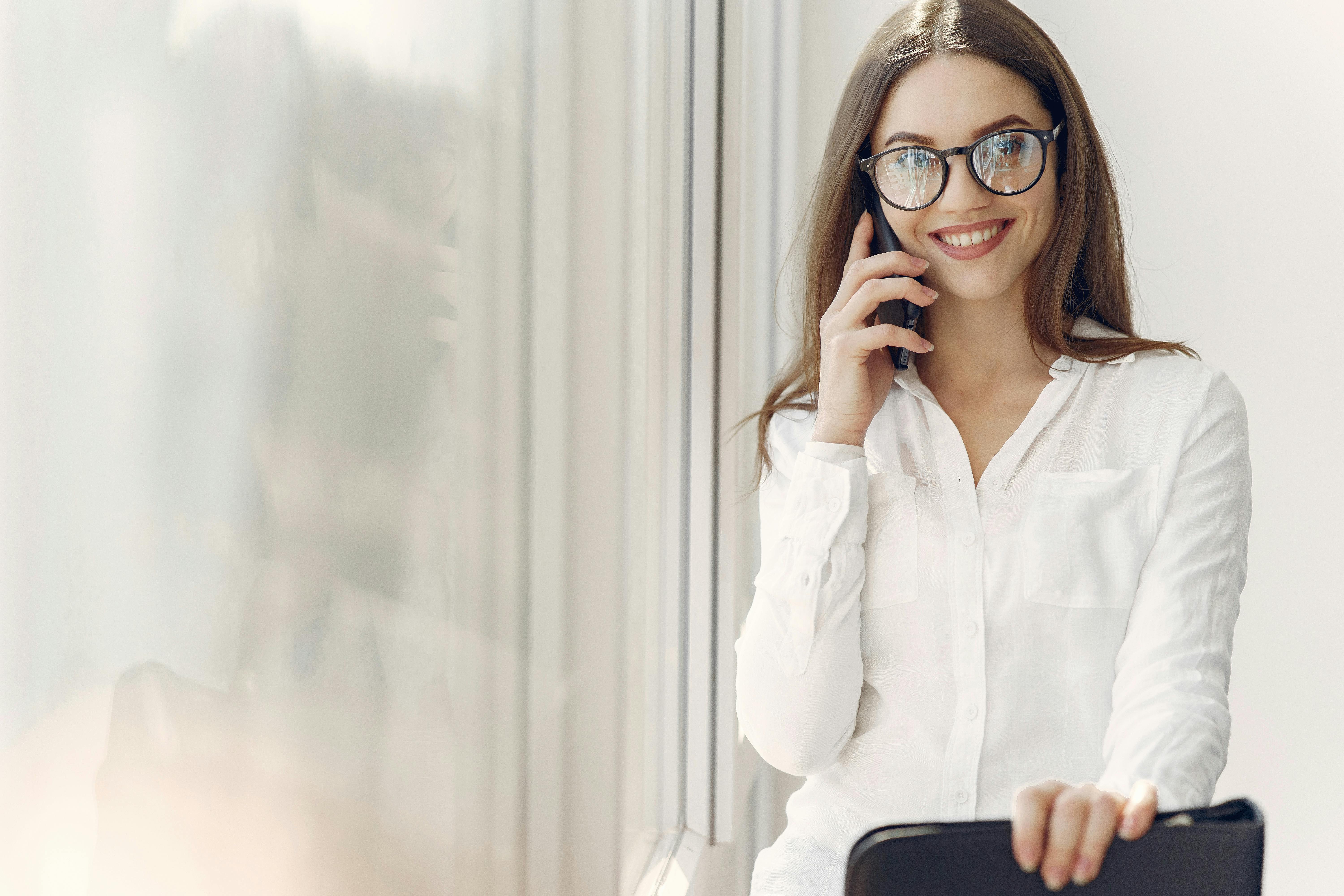 Una mujer sonriente en una llamada telefónica | Fuente: Pexels