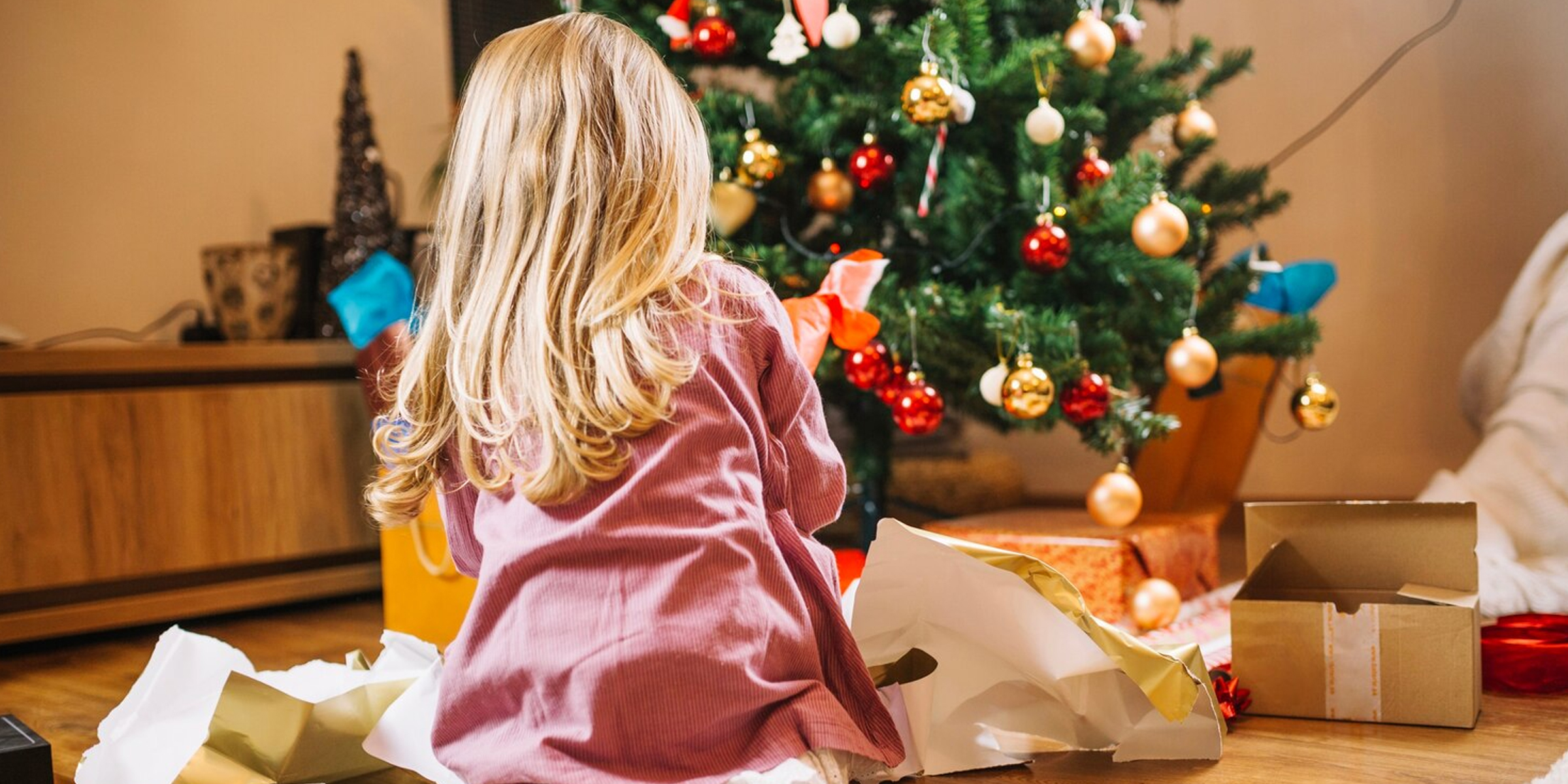 Una niña abriendo regalos de Navidad | Fuente: FreePik