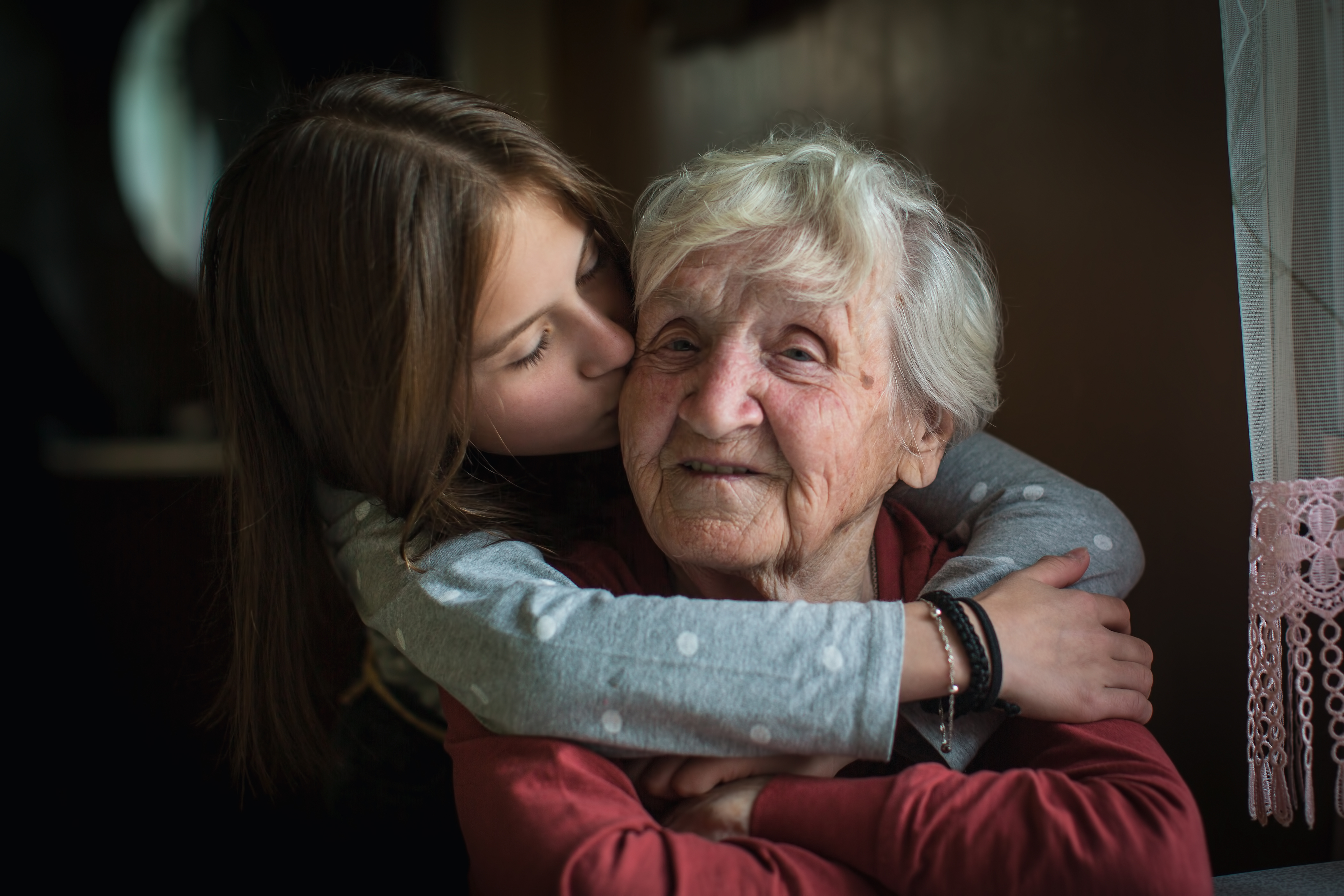 Chica besa a su abuela en la mejilla | Foto: Shutterstock