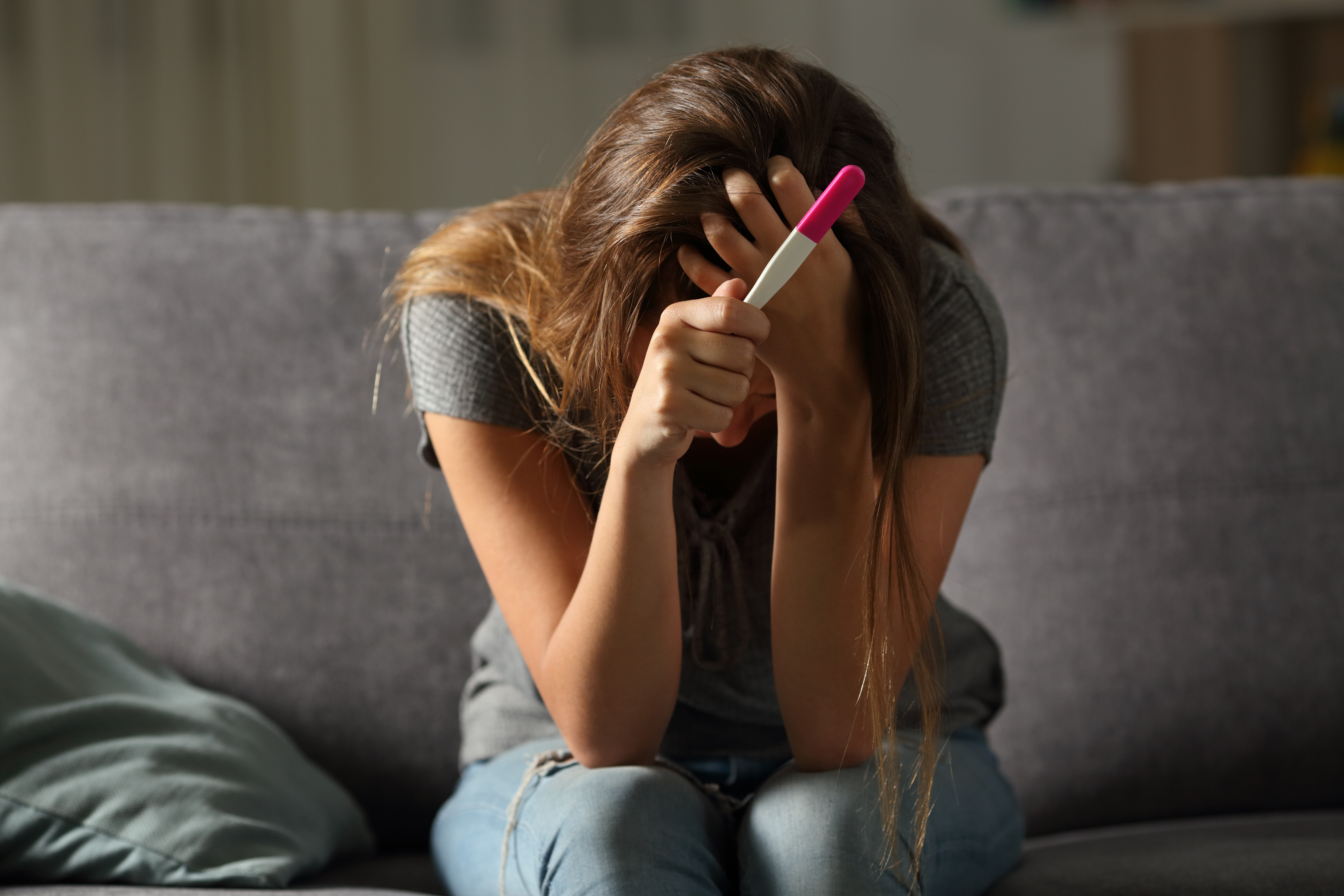 Mujer triste sosteniendo una prueba de embarazo | Fuente: Shutterstock