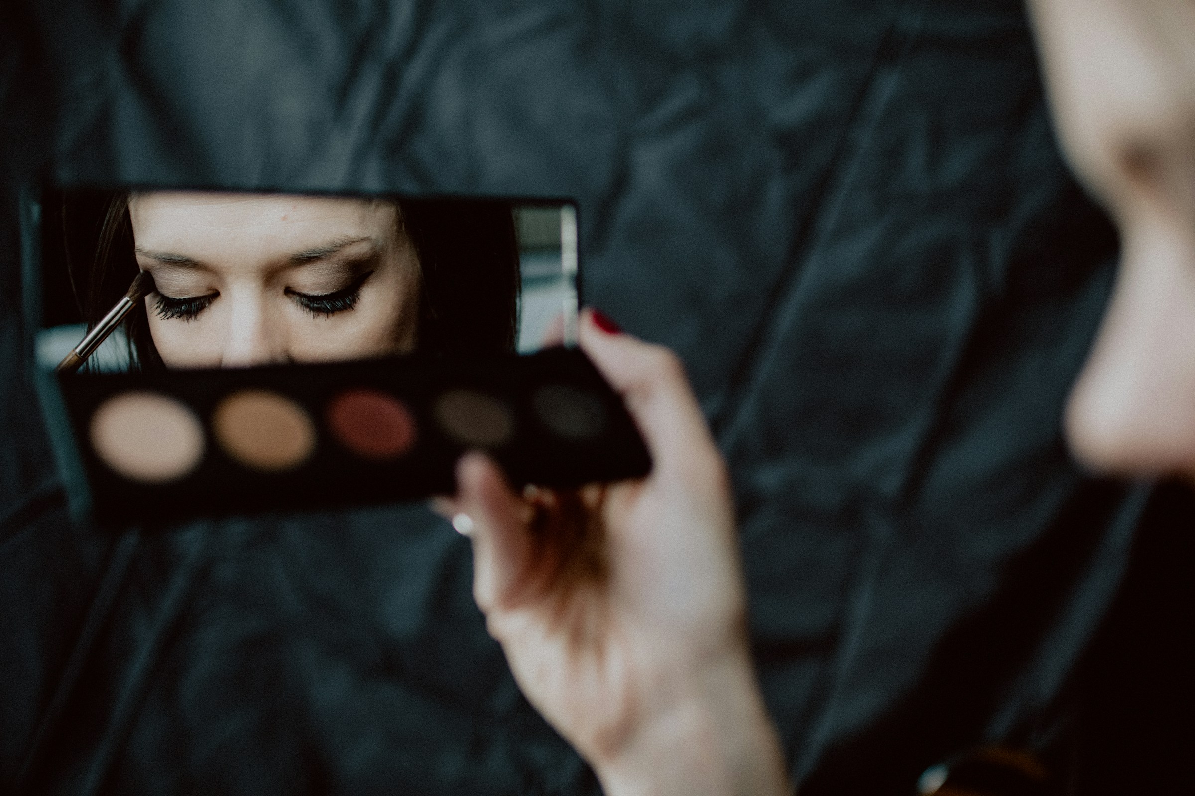 Primer plano de una mujer aplicándose sombra de ojos | Fuente: Unsplash