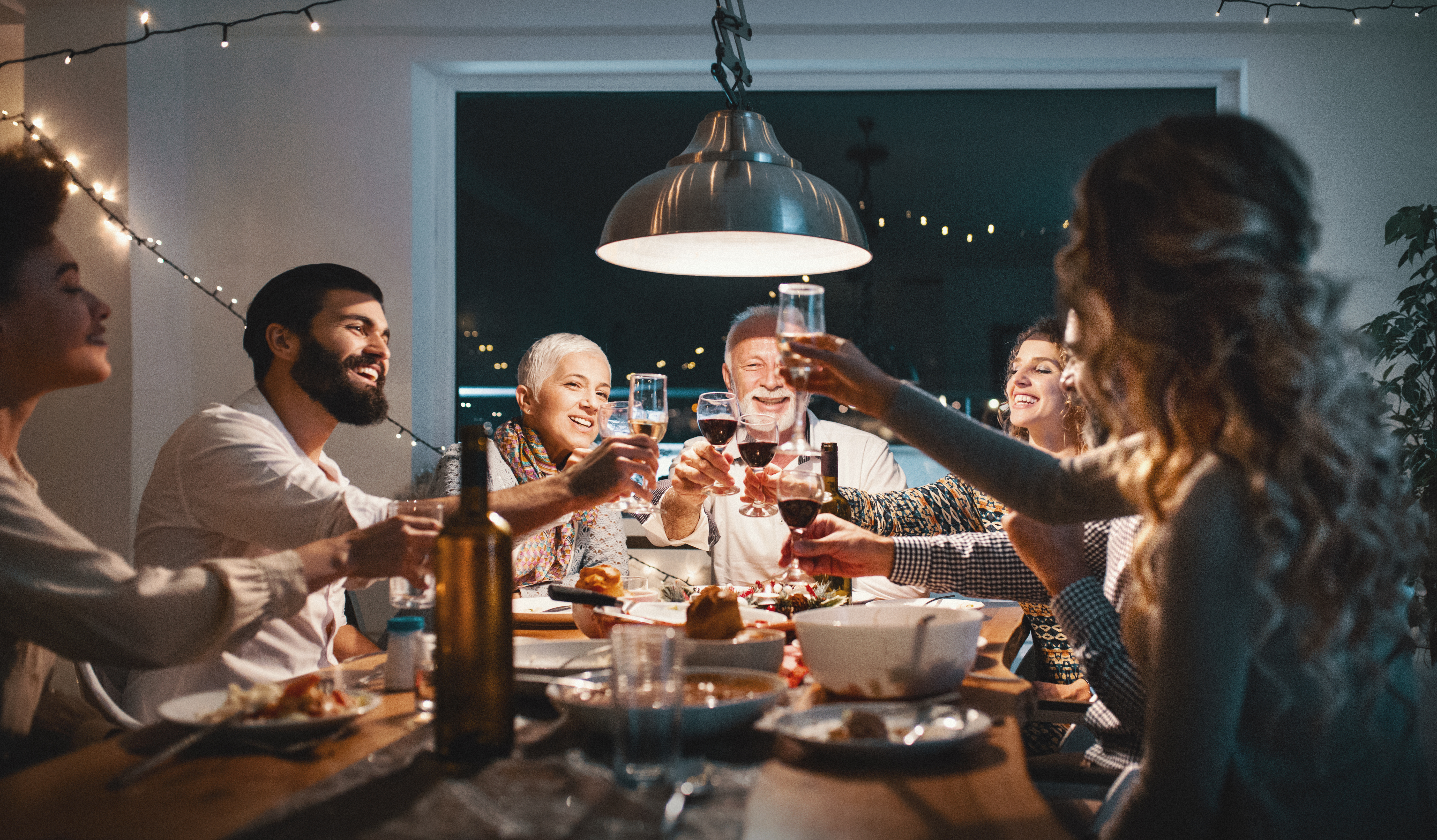 Una familia brindando durante la cena | Fuente: Getty Images