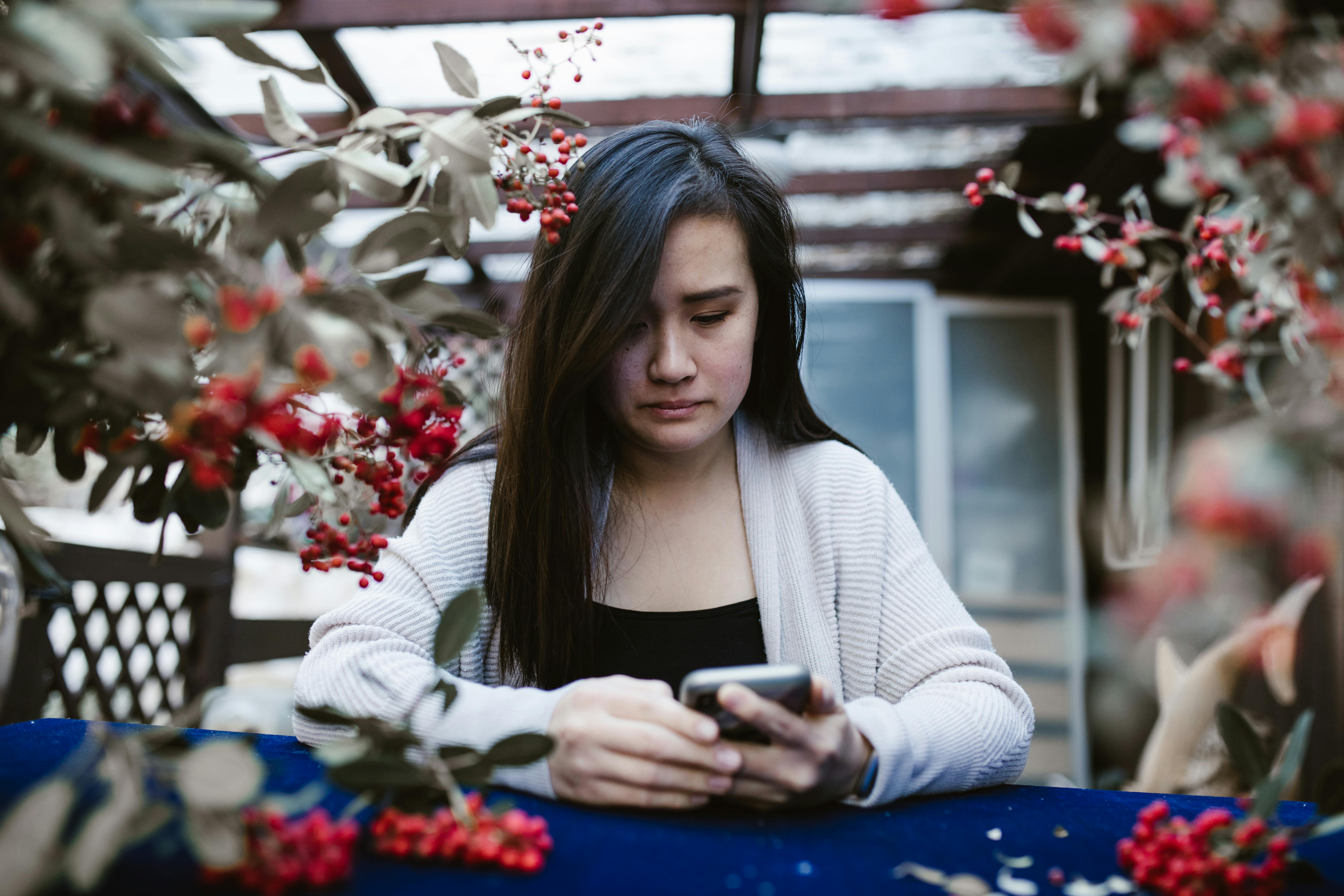 Una mujer triste mirando su teléfono | Fuente: Pexels