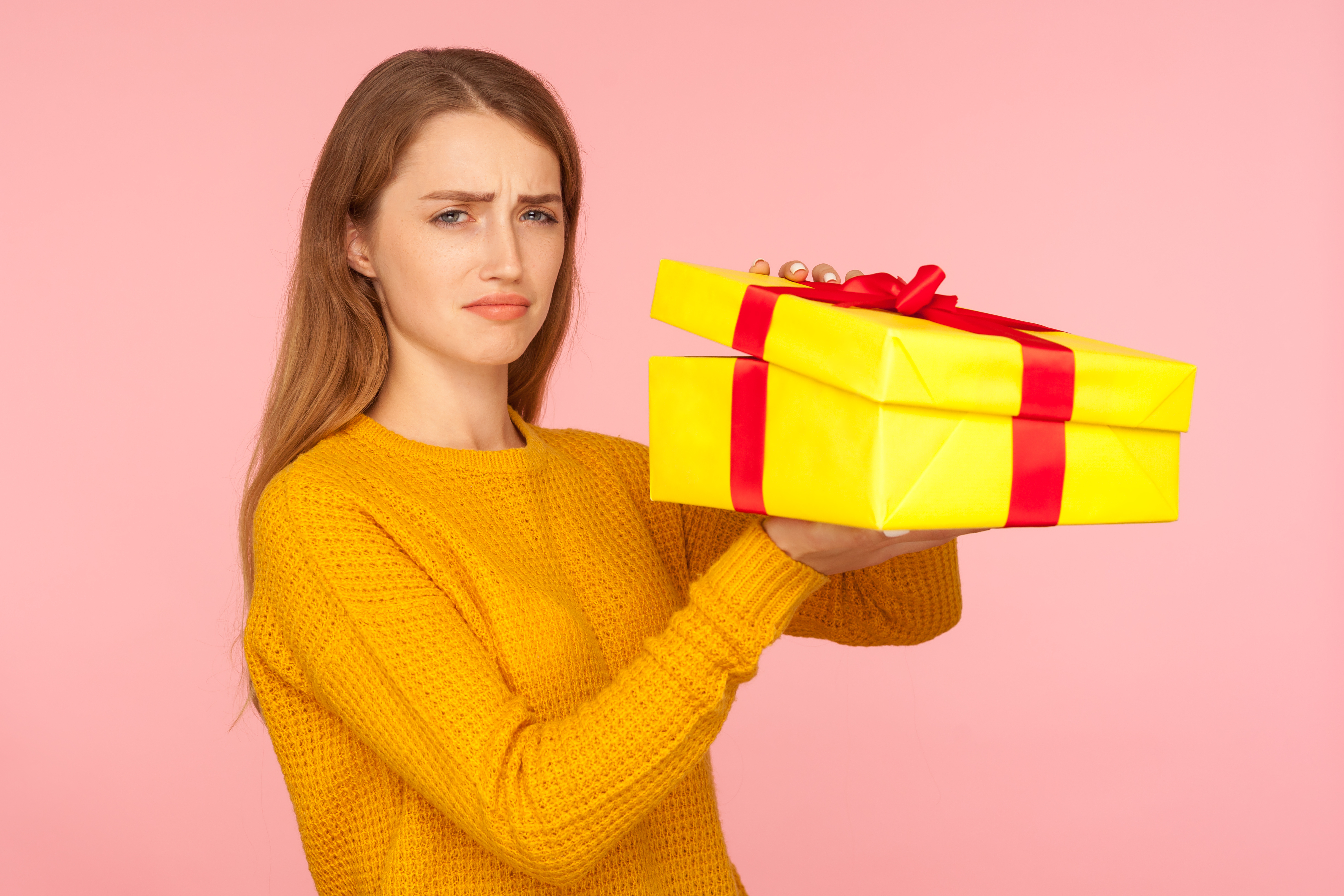 Una mujer decepcionada sosteniendo un regalo | Foto: Getty Images