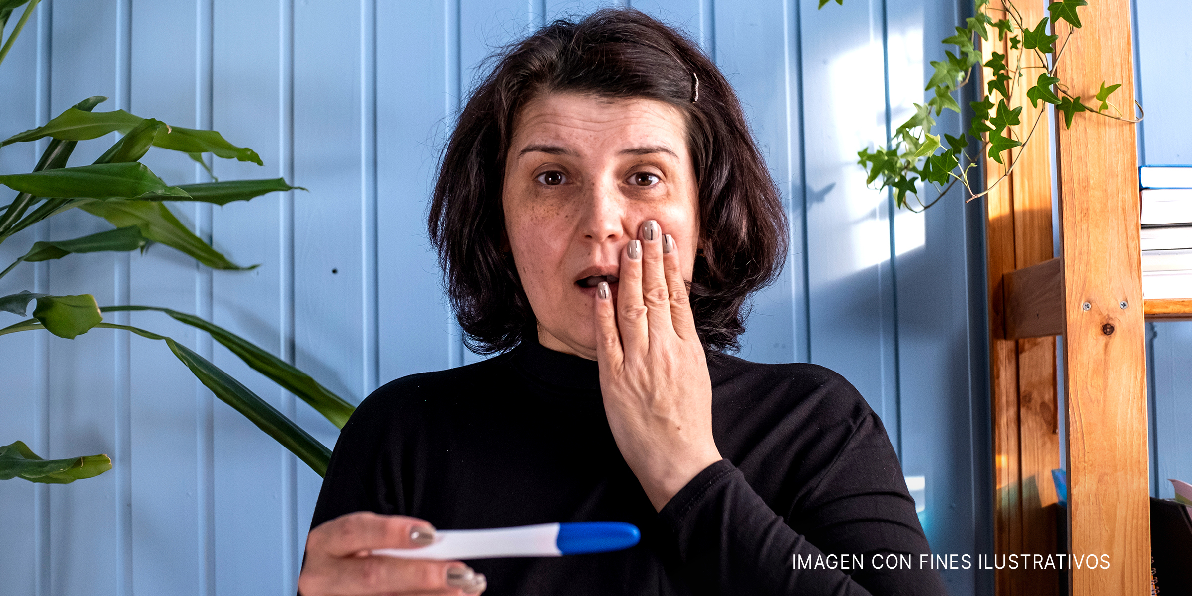 Una mujer de mediana edad mirando el resultado de una prueba de embarazo que da positivo. | Foto: Shutterstock