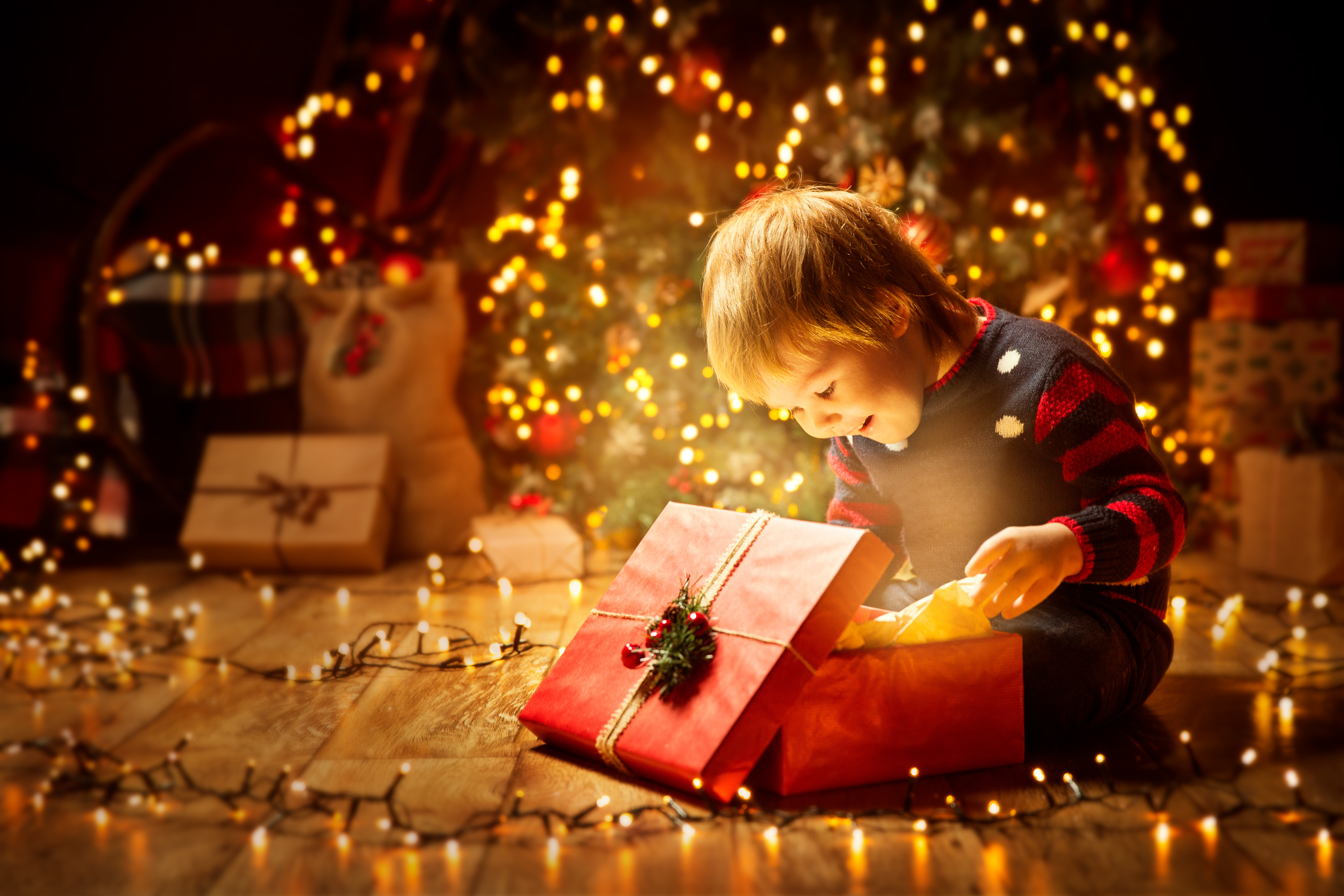 Un niño abriendo una caja de regalos de Navidad. | Foto: Shutterstock